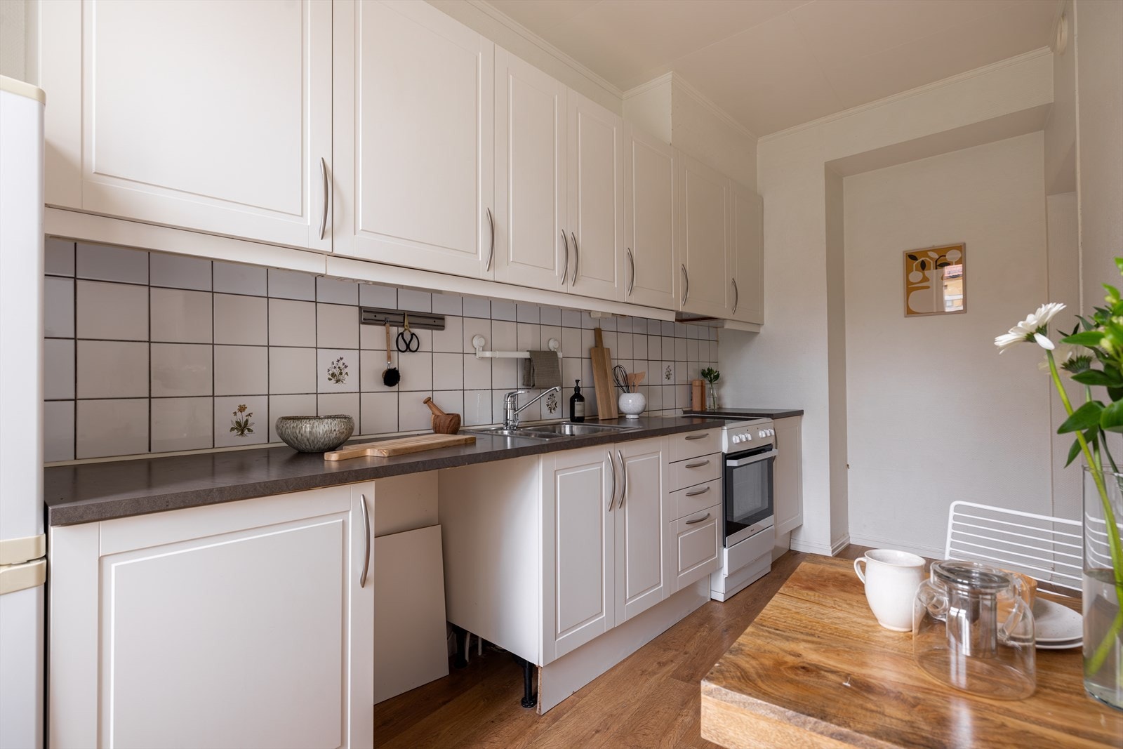 Kjøkkenet er innredet med hvit mattlakket kjøkkeninnredning med profilerte fronter fra Norema. Galleribilde