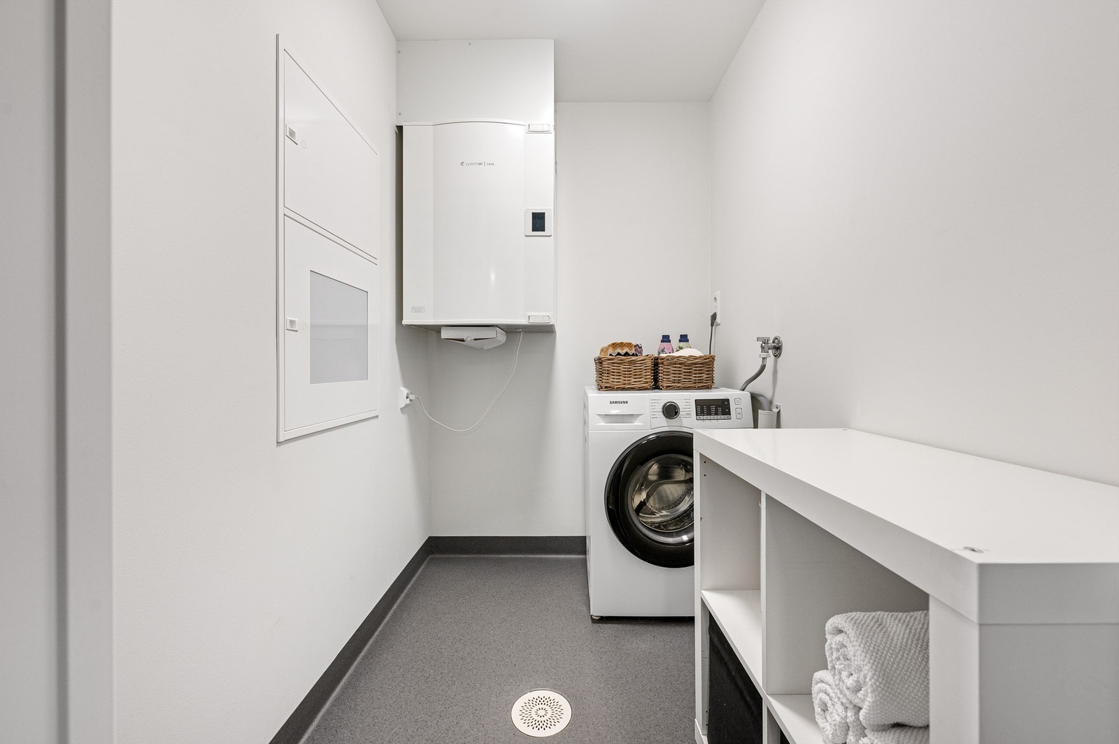 Vaskerommet har belegg på gulv og opplegg for vaskemaskin. Ventilasjons-aggregat og sikringsskap Galleribilde