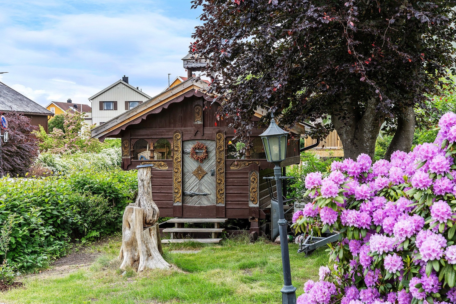 Rhododendron er i full blomst. Avbildet stabbur medfølger ikke i handelen. Galleribilde