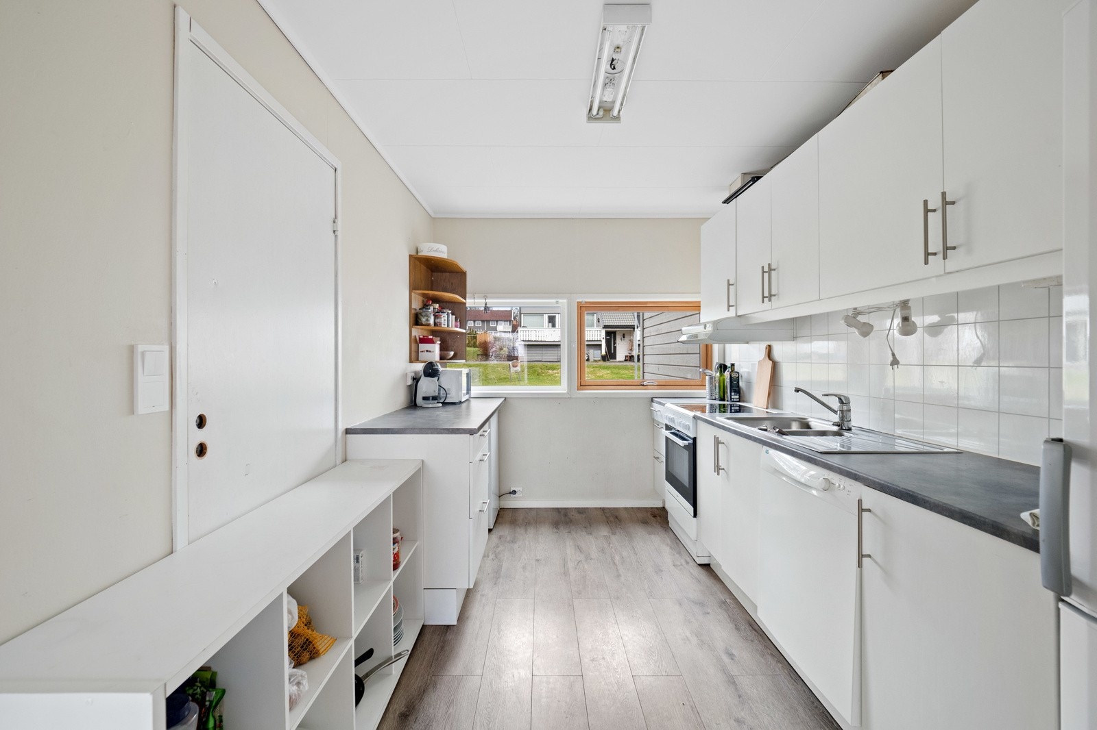 Kjøkkenet ligger noe avskjermet fra stuen og har rikelig med skap- og benkeplass Galleribilde