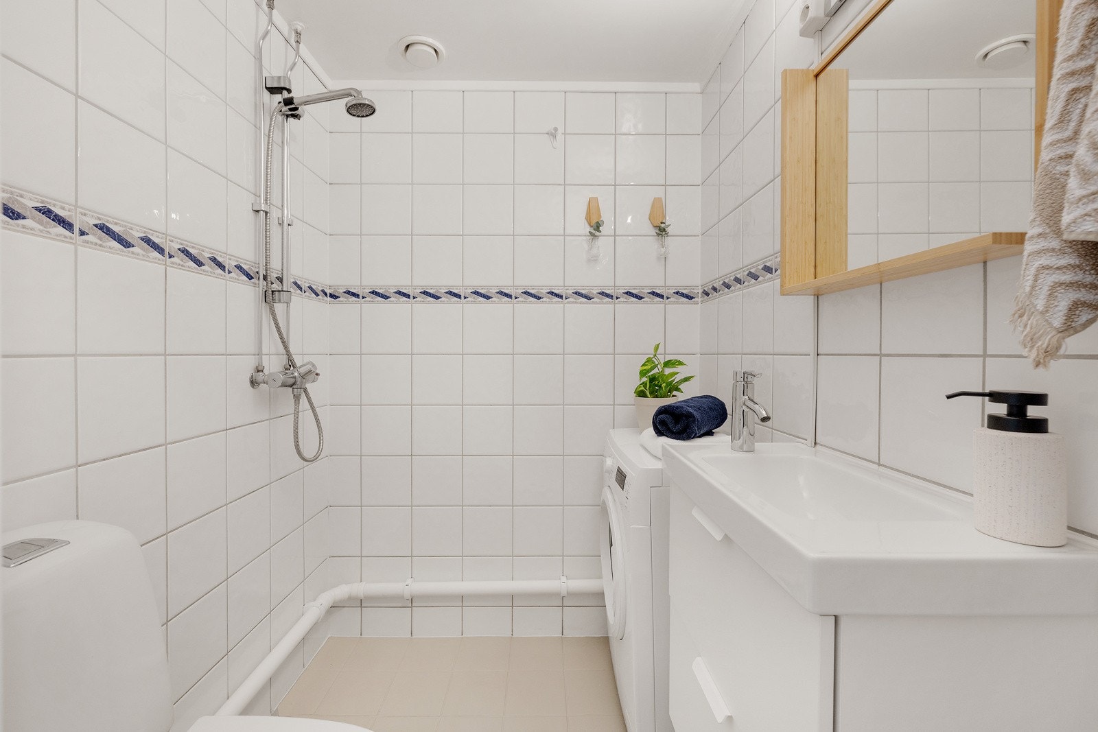 Flislagt baderom med gulvvarme og opplegg for vaskemaskin. Galleribilde