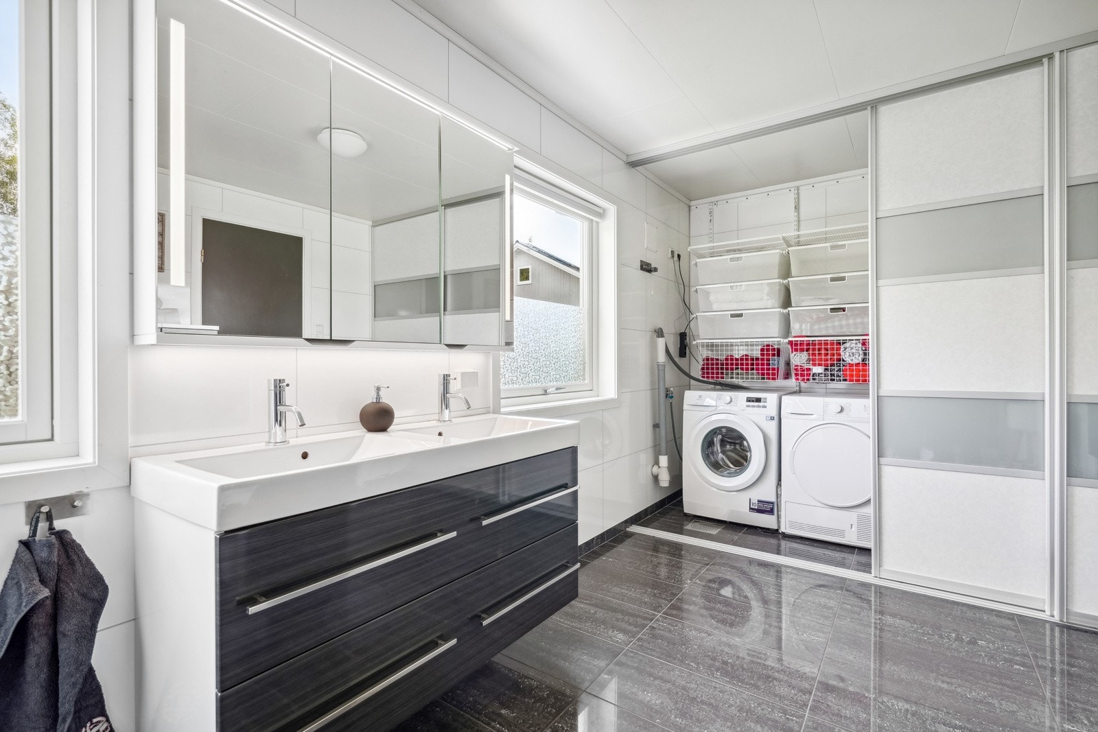 På badet er det også gulvvarme og opplegg for vaskemaskin. Vaskemaskinen er praktisk plassert bak skyvedører. Galleribilde