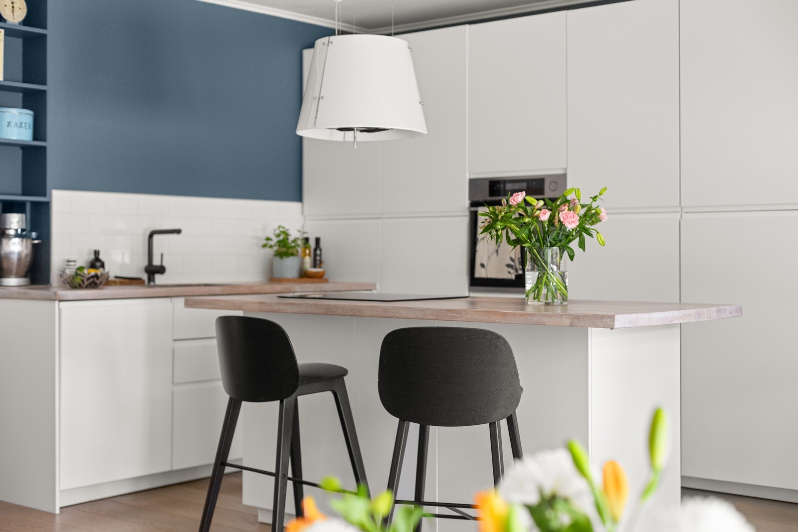 Romslig kjøkken med høyskap og kjøkkenøy som gir to ekstra sitteplasser. Galleribilde