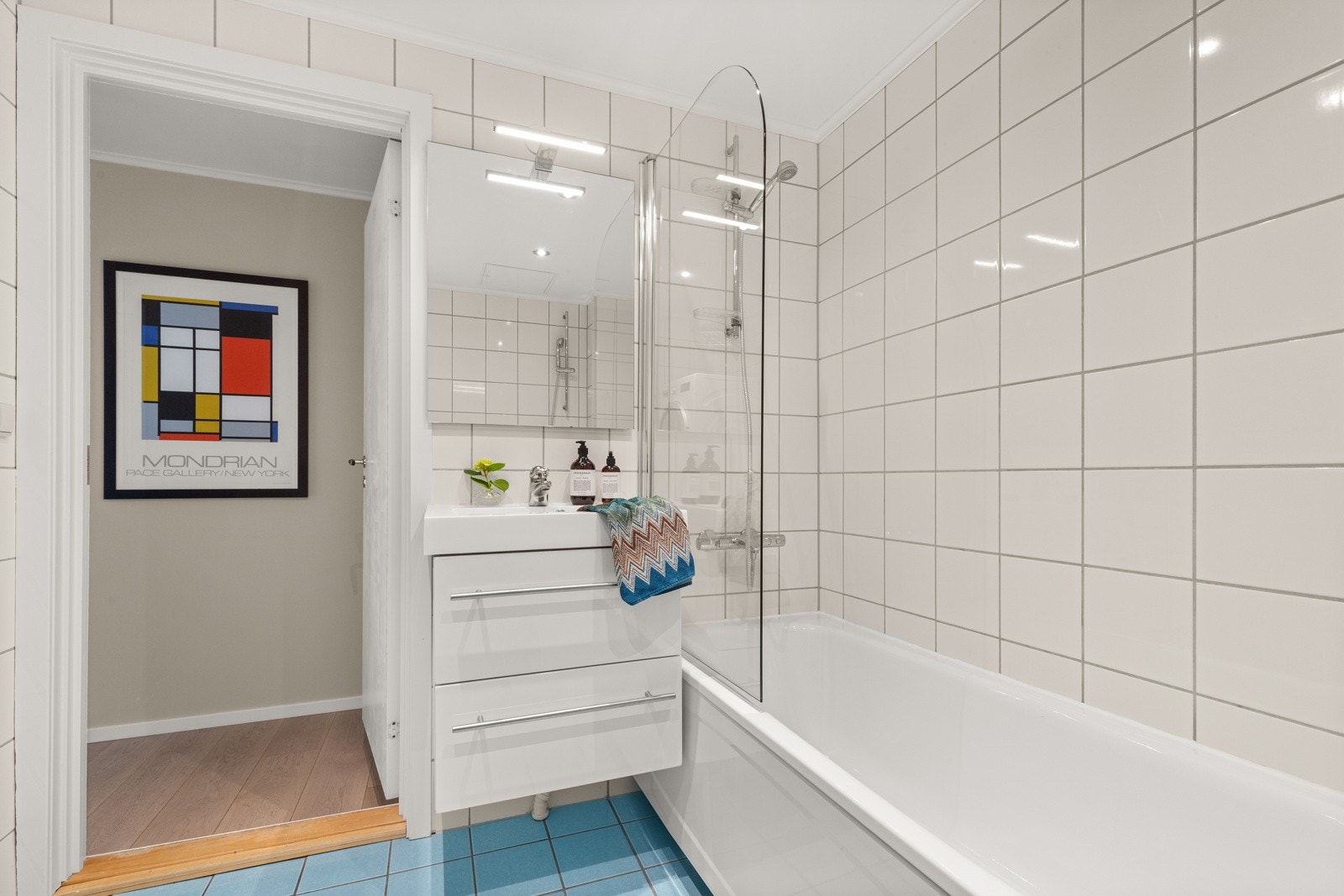 Boligens bad har flislagte vegger og gulv med varmekabler. Galleribilde