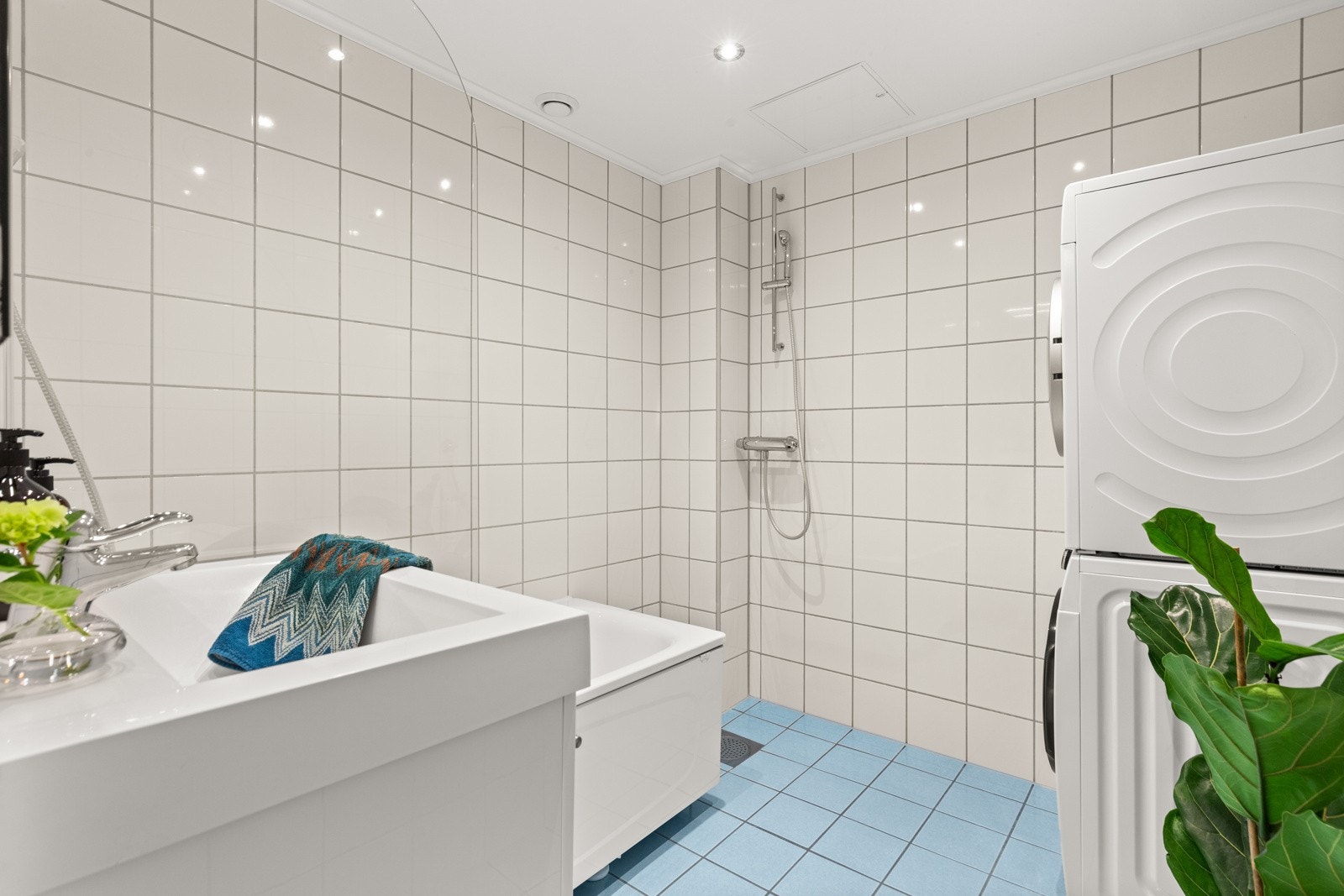 Badet er innredet med servant med skuffeseksjon, badekar med dusj og opplegg for vaskemaskin samt tørketrommel. Galleribilde