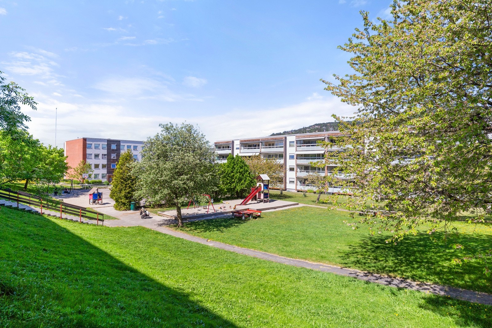 Det er store grøntarealer rundt leilighetene, og det gjør det trivelig å bo her. Galleribilde