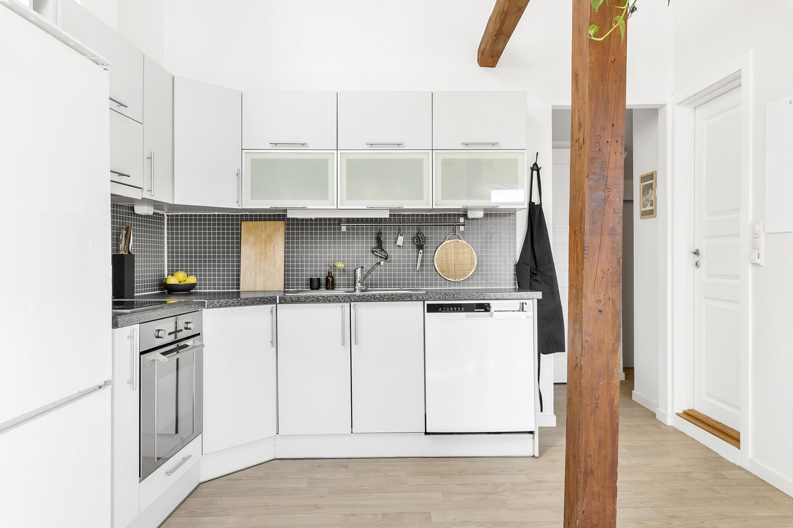 Lyst kjøkken som har godt med skap -og benkeplass. Galleribilde