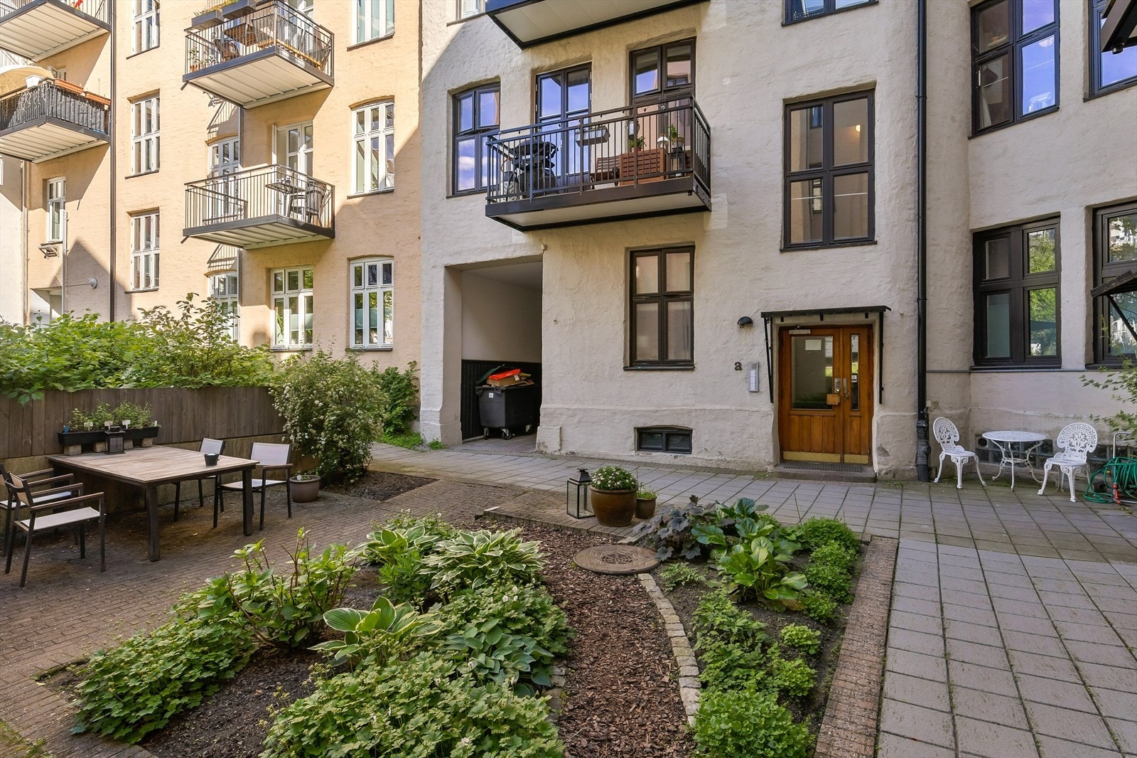 Pent opparbeidet bakgård med sittegrupper og flott beplantning. Galleribilde