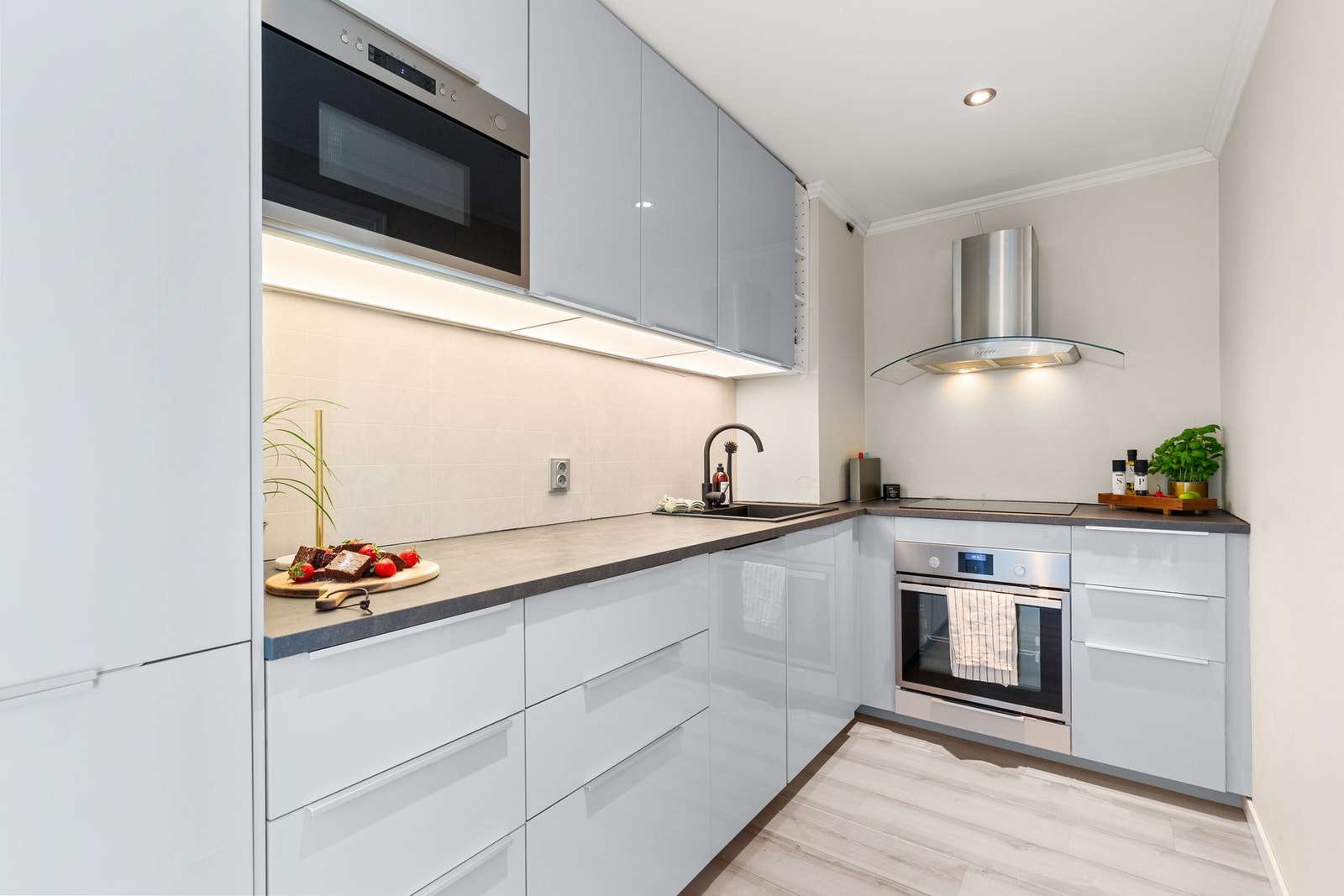 Flott nyere kjøkken i høyglans med mye benke- og skapplass Galleribilde