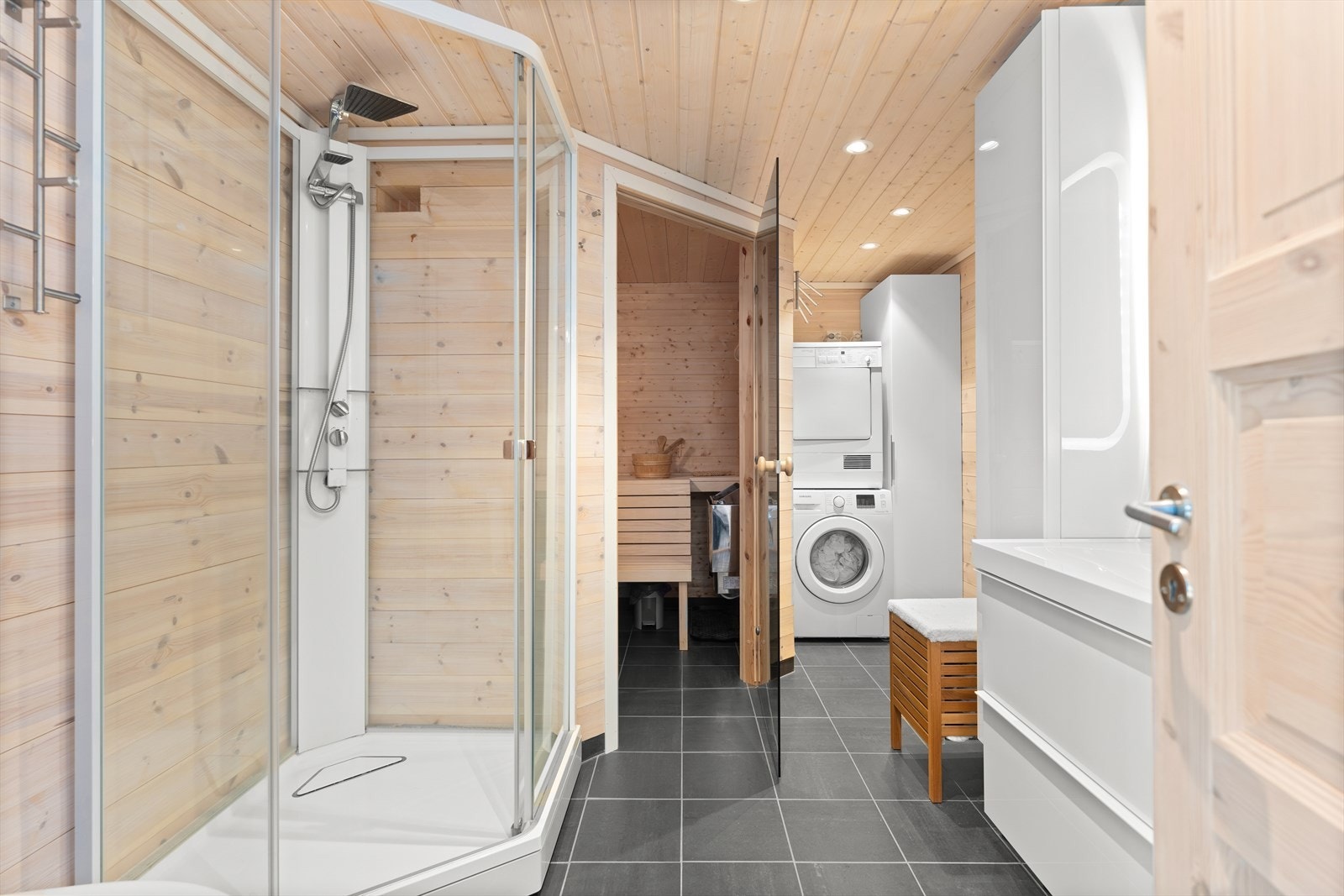Badet er innredet med dusjkabinett, badstue og opplegg for vaskemaskin Galleribilde