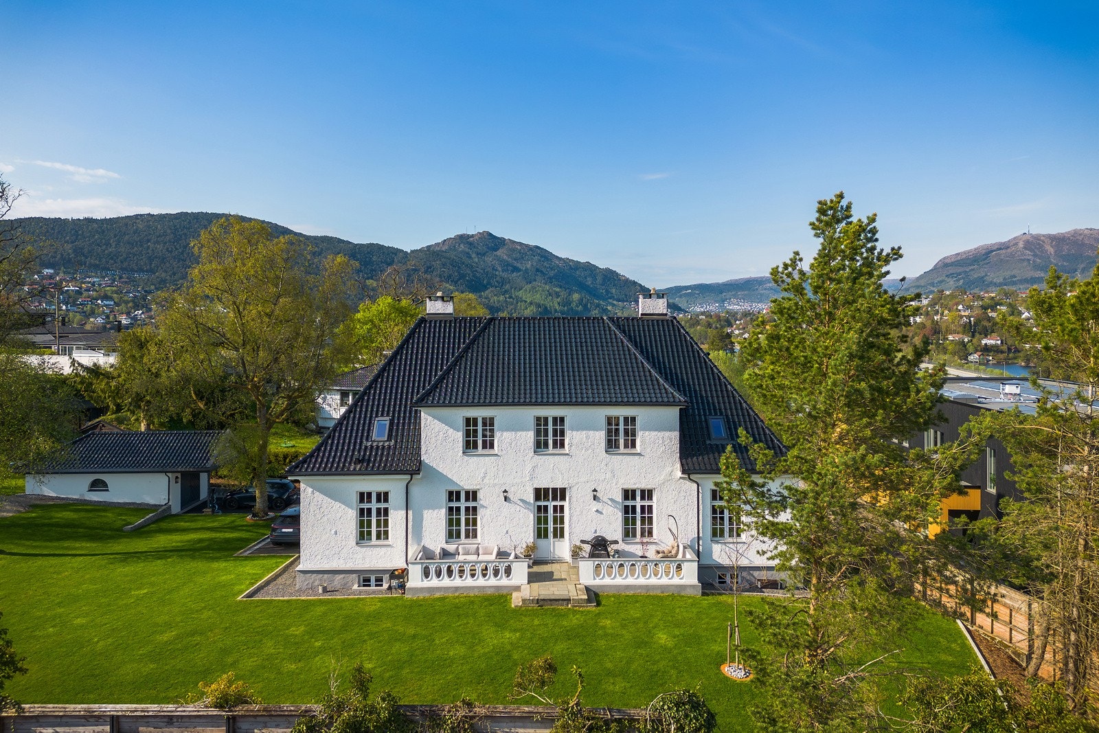 I front er eiendommen opparbeidet bed med kantstein, asfalt og brostein. Tomten for øvrig er opparbeidet med gressplen og kantstein som innramming. Galleribilde