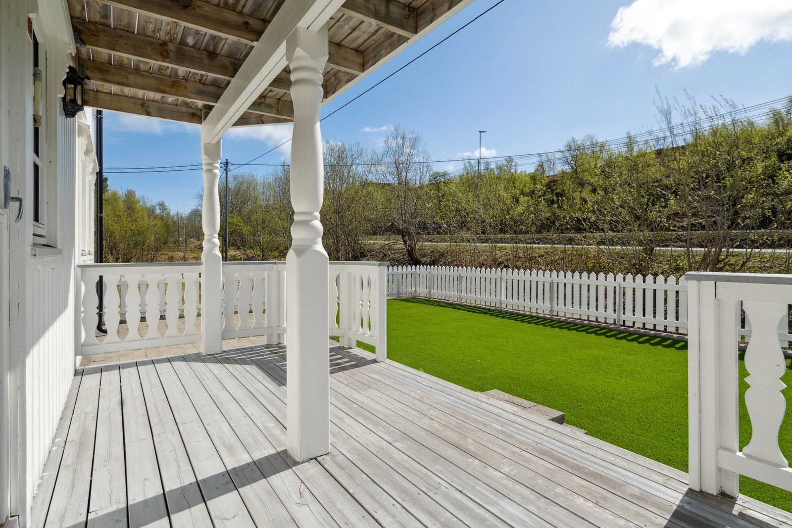 Fra terrassen kan du gå ned til en perfekt plen som alltid er grønn - kunstgress er tingen på hytta. Galleribilde