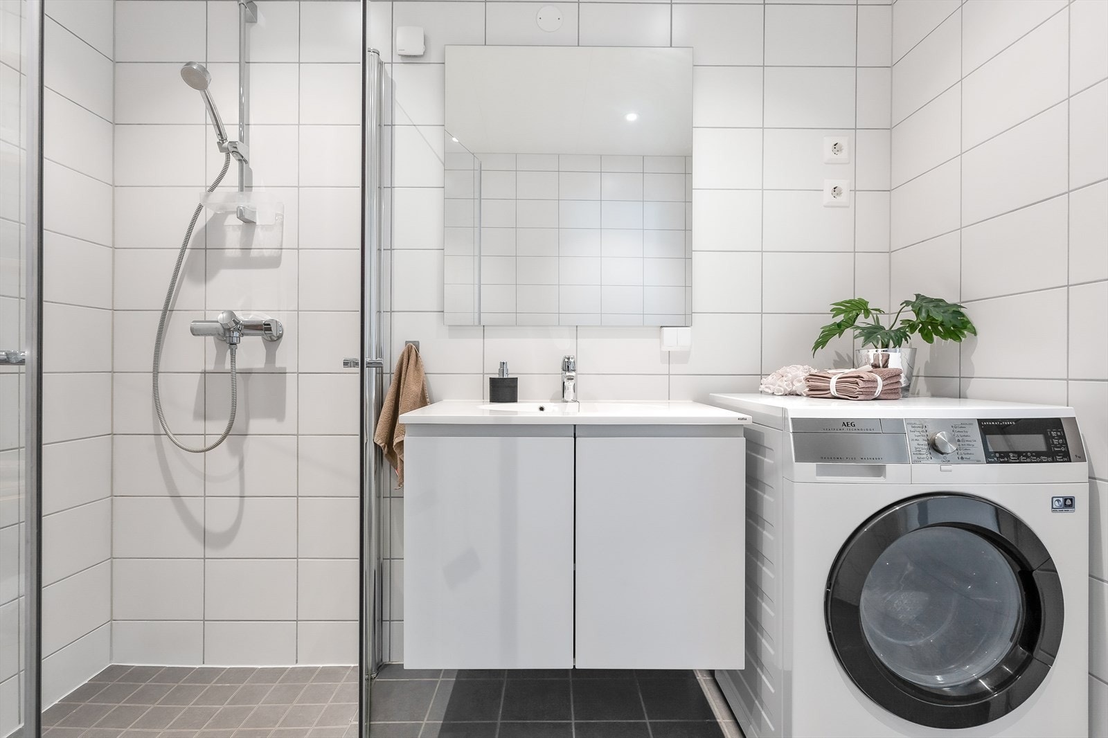 Moderne bad med plass for vaskemaskin og stilrene fliser Galleribilde