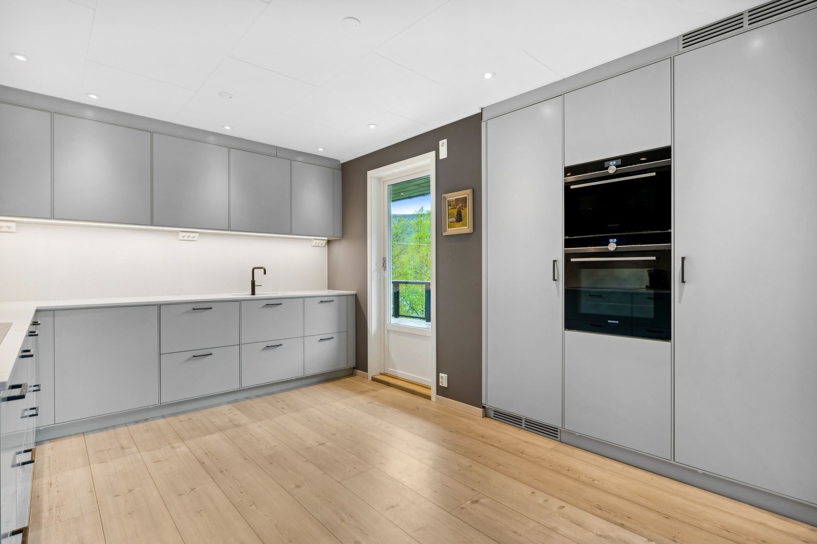 som koketopp, kombiovn, dampovn, kjøleskap, samt en Miele oppvaskmaskin Galleribilde