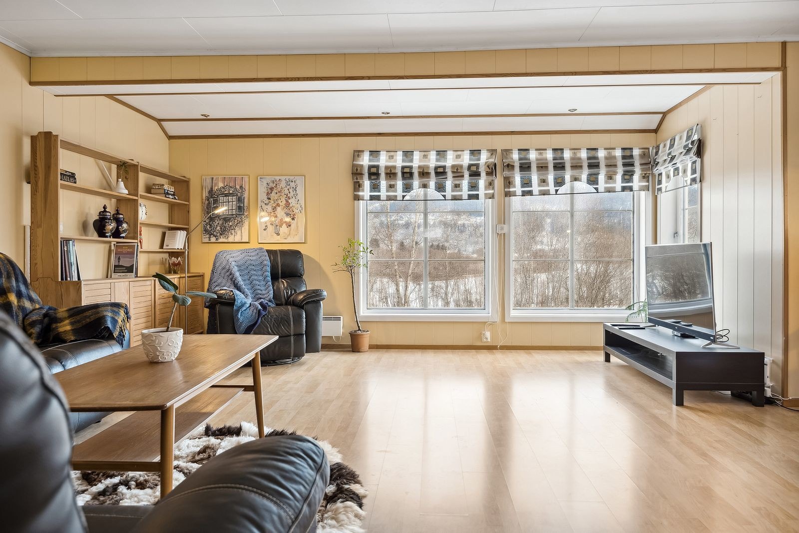 Store, flotte vinduer tillater rikelig med sollys inn på stuen, som reflekteres rundt hele rommet. Galleribilde