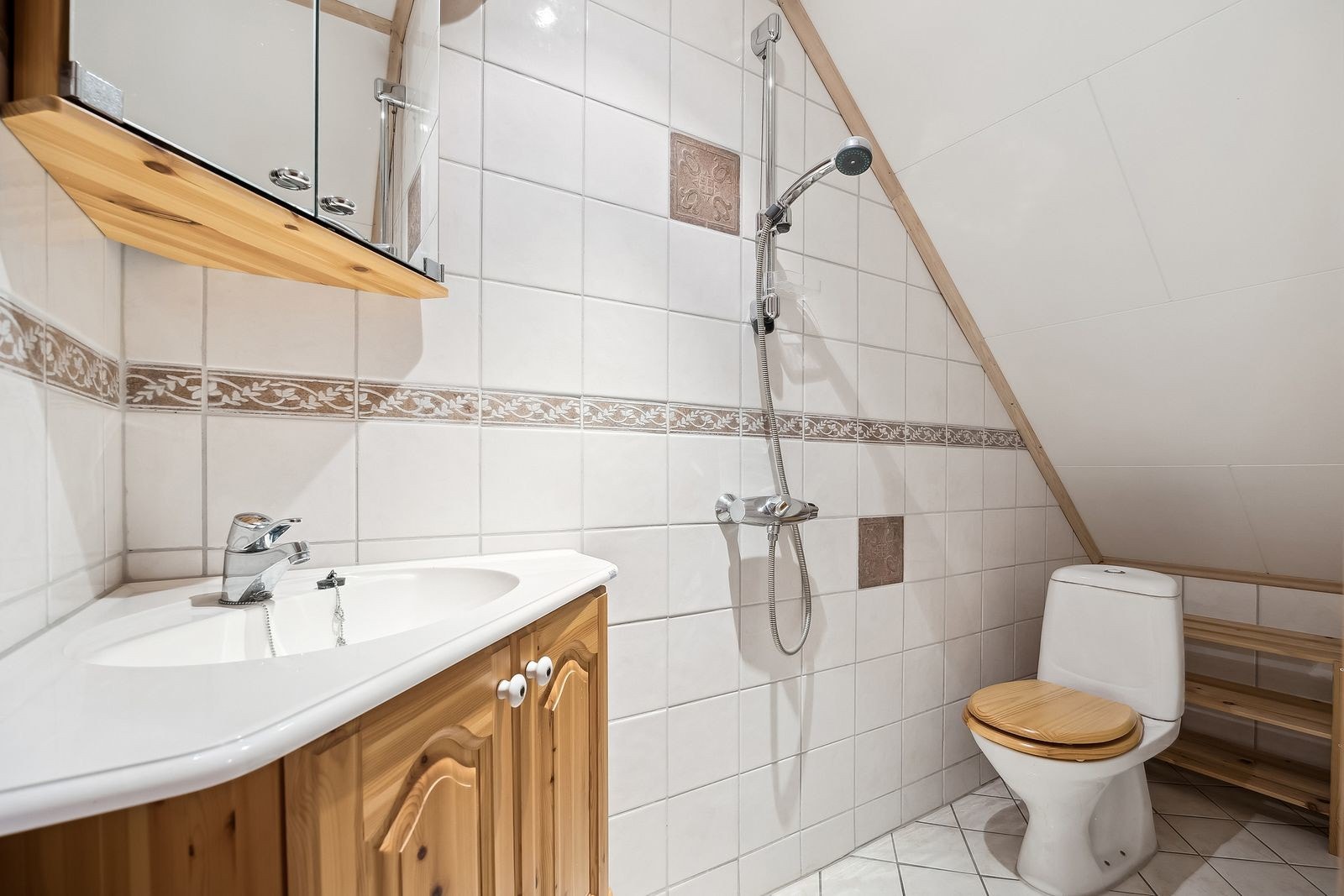 Badet har vakre fliser på både vegg og gulv og mekanisk avtrekkfsvifte i veggen. Galleribilde