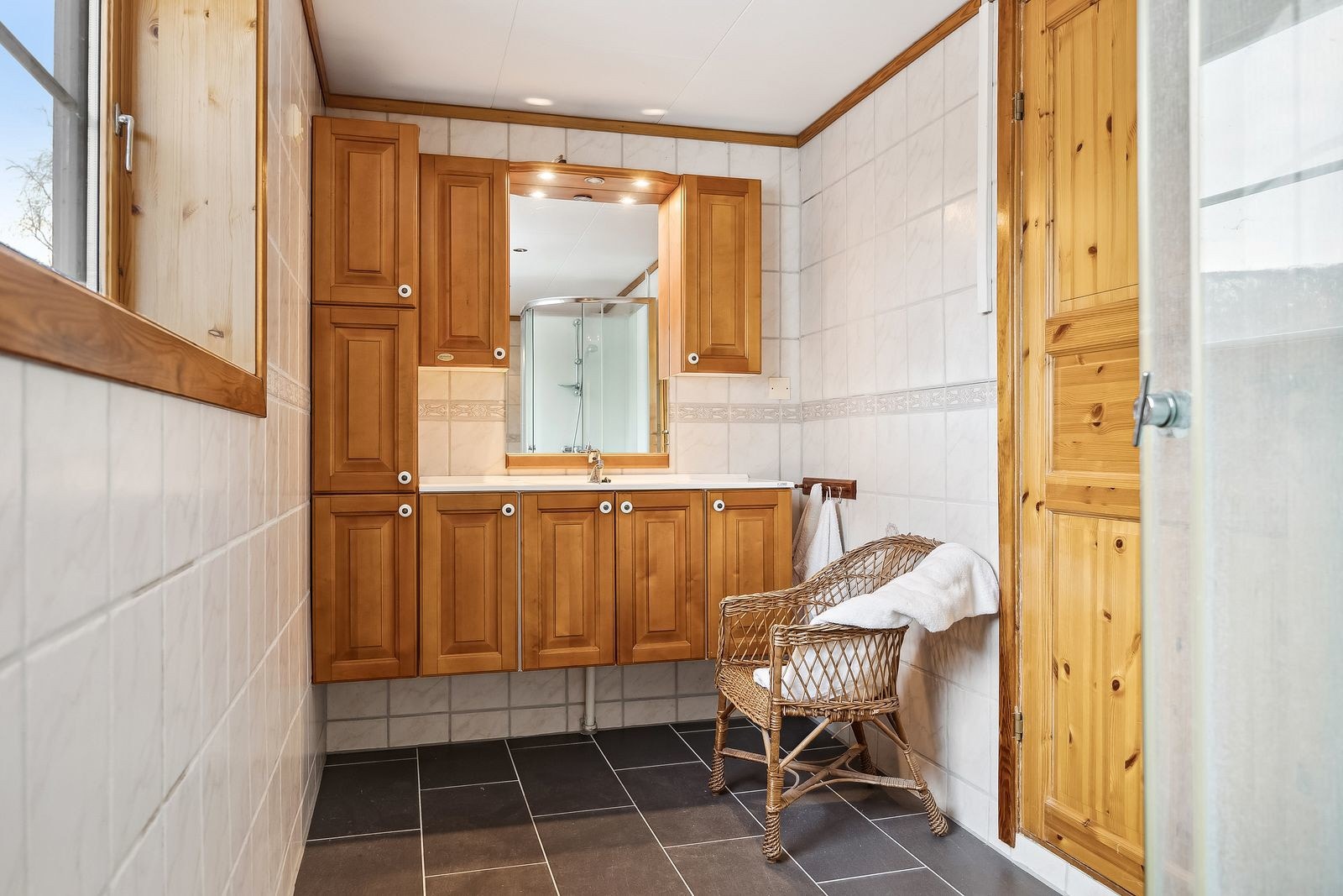 Badet i kjellerstuen har fliser på både vegg og gulv, gulvvarme og mekanisk avtrekk med ventil i vegg. Galleribilde