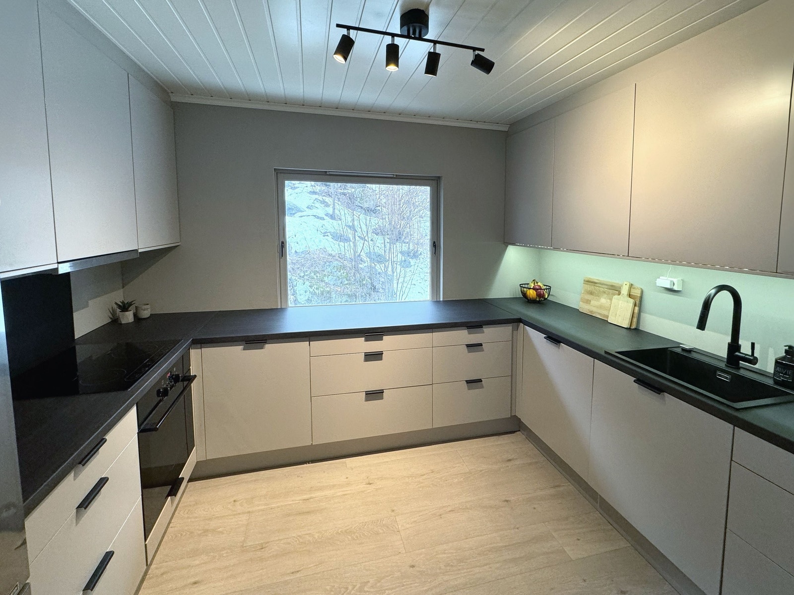 Nytt kjøkken fra 2023 med stilrene fronter, slette vegger mellom overskap og underskap, samt laminert benkeplate. Preget av sorte, lekre detaljer. Galleribilde