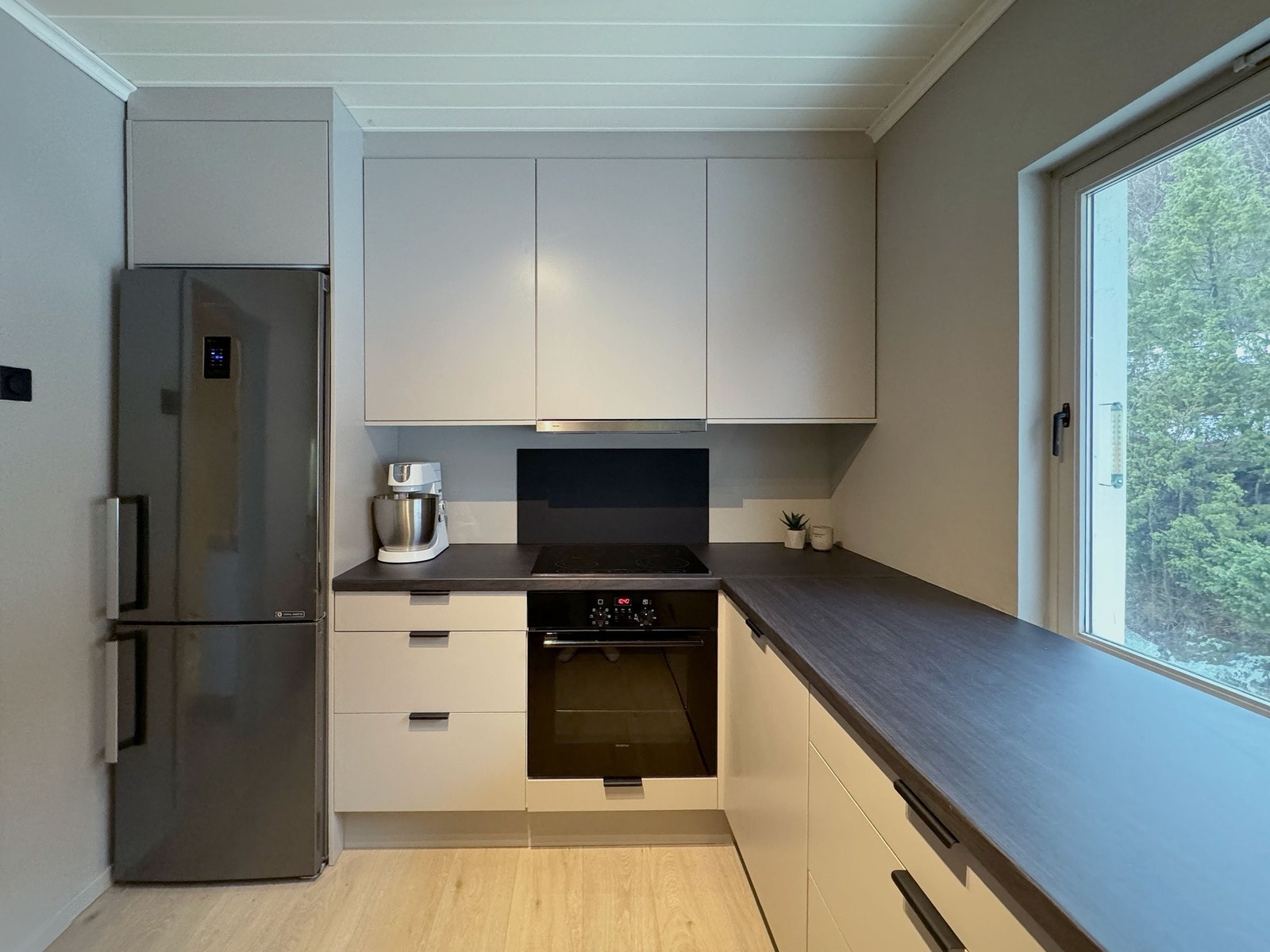 Kjøkkenet har god oppbevaringsplass og stort vindu som bidrar til naturlig belysning. Galleribilde