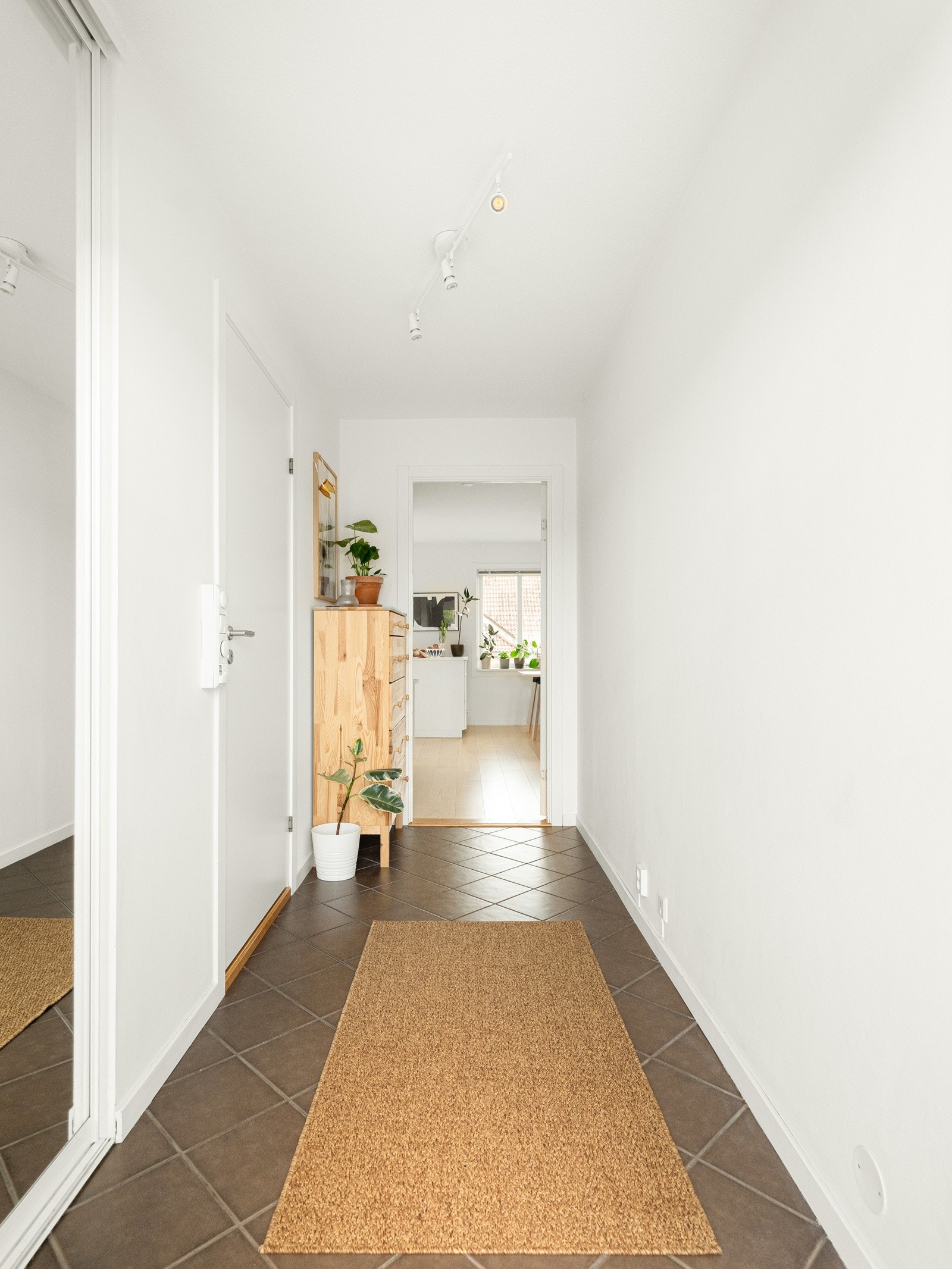 Vi tar turen inn igjen. Entreen er praktisk flislagt, har skyvedørsgarderobe for oppheng, samt plass til kommode. Galleribilde