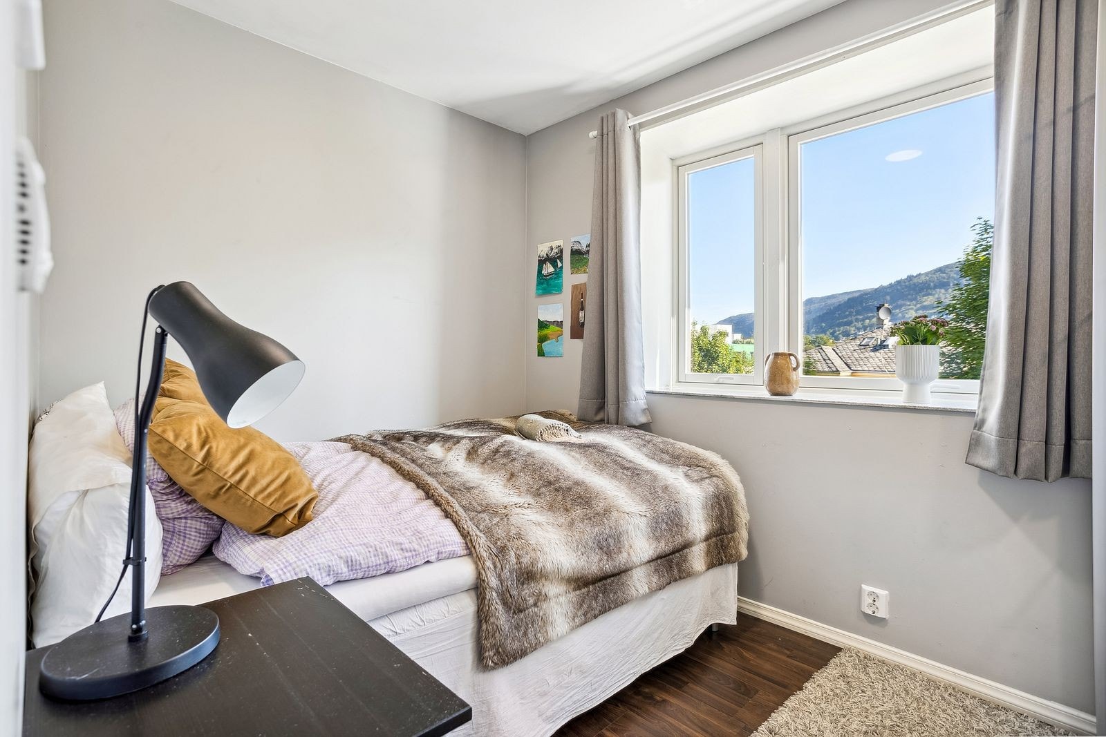 Lyst og trivelig soverom med plass til seng, nattbord og garderobe/kommode Galleribilde