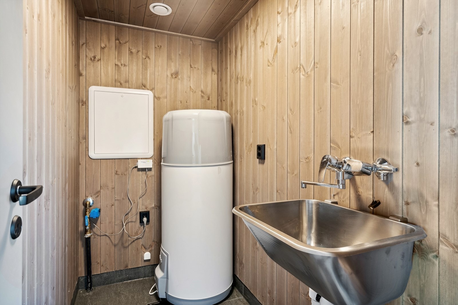 Det er opplegg for vaskemaskin i hyttas praktiske bod/tekniske rom. Her er det med flislagt gulv, stålkum på vegg, varmtvannsbereder og muligheter for ekstra oppbevaring. Galleribilde