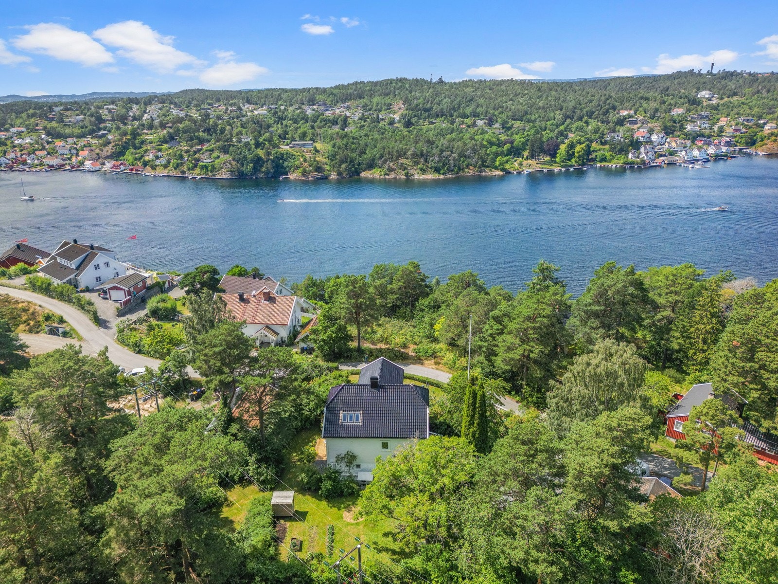 Tomten er på ca.1,4 mål, fint rammet inn av en hekk og et hvitmalt gjerde. Galleribilde