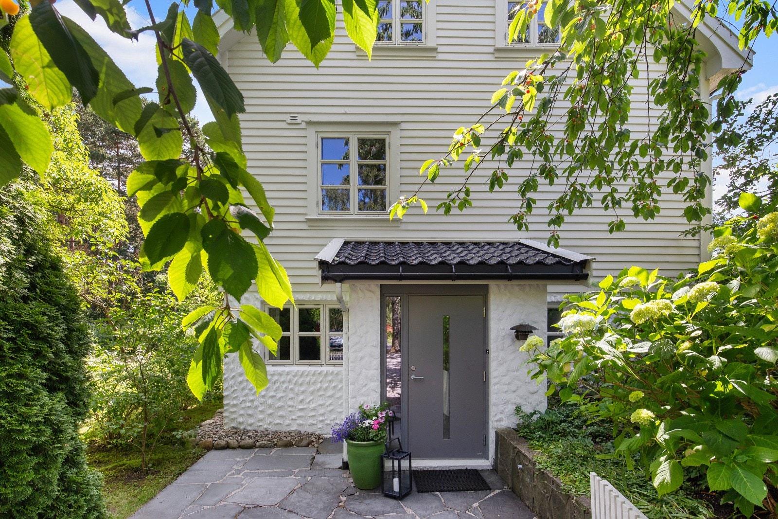 Et overbygd og godt skjermet inngangsparti ønsker velkommen til selve villaen, et stort og vakkert hus over tre plan. Galleribilde