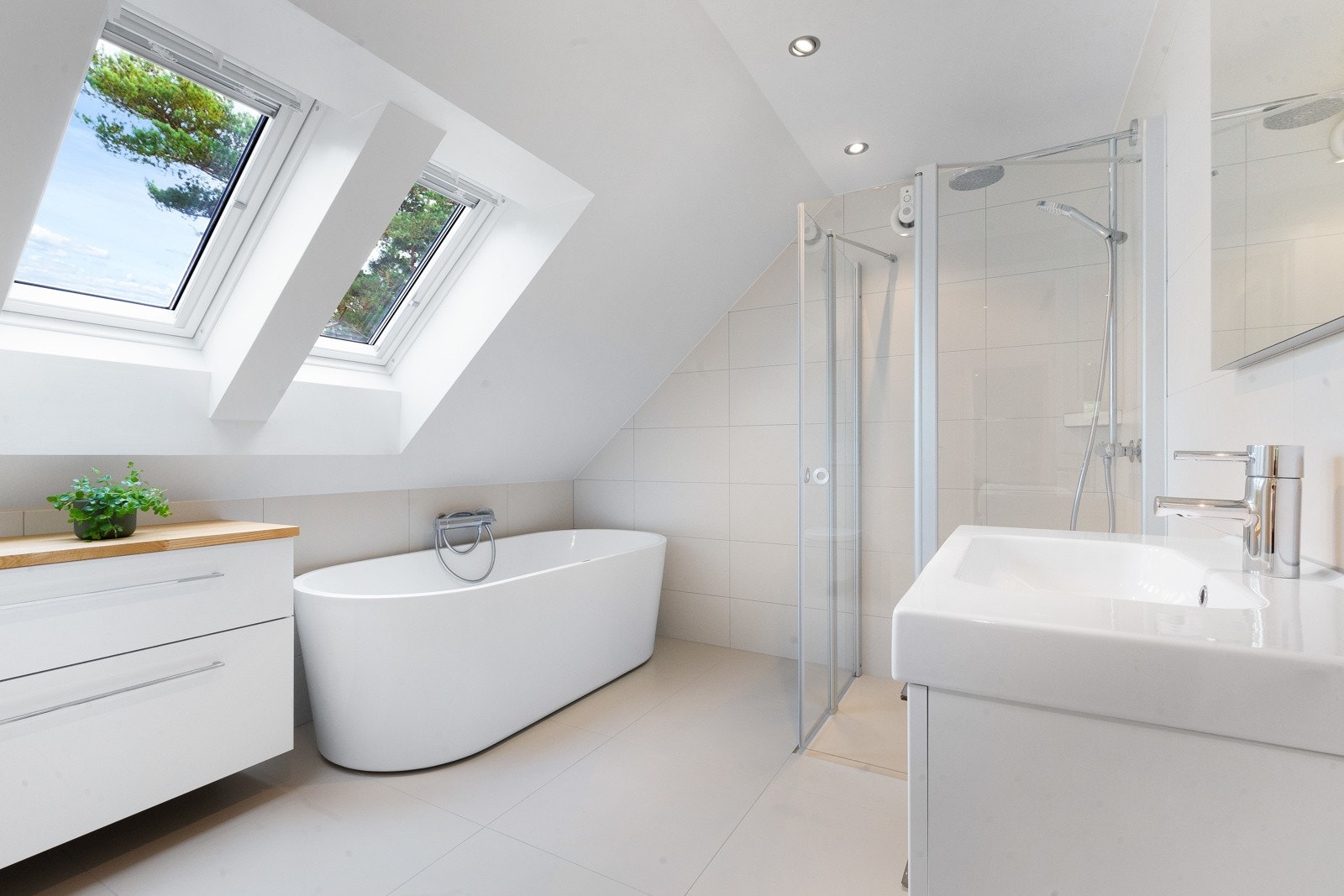 Badet oppe har både et dusjhjørne og et deilig badekar plassert under to takvinduer. Galleribilde