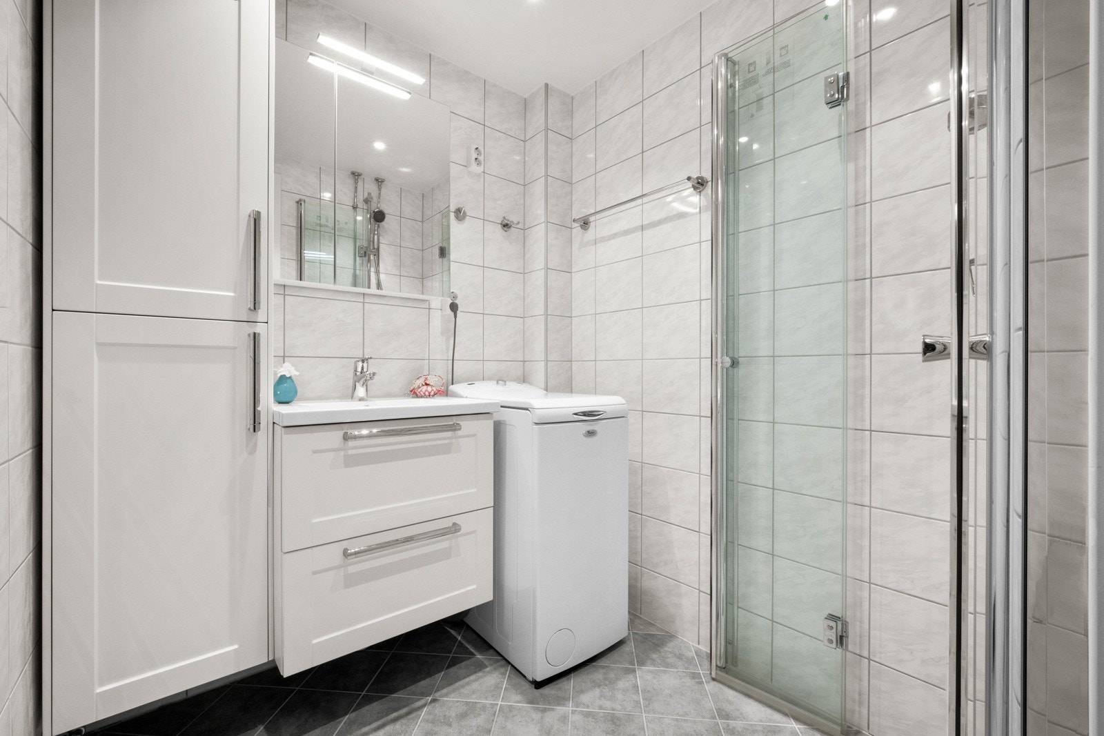 Badet er pent og har et praktisk dusjhjørne, samt plass til vaskemaskin - noe som gir deg en komfortabel og praktisk hverdagsløsning. Galleribilde