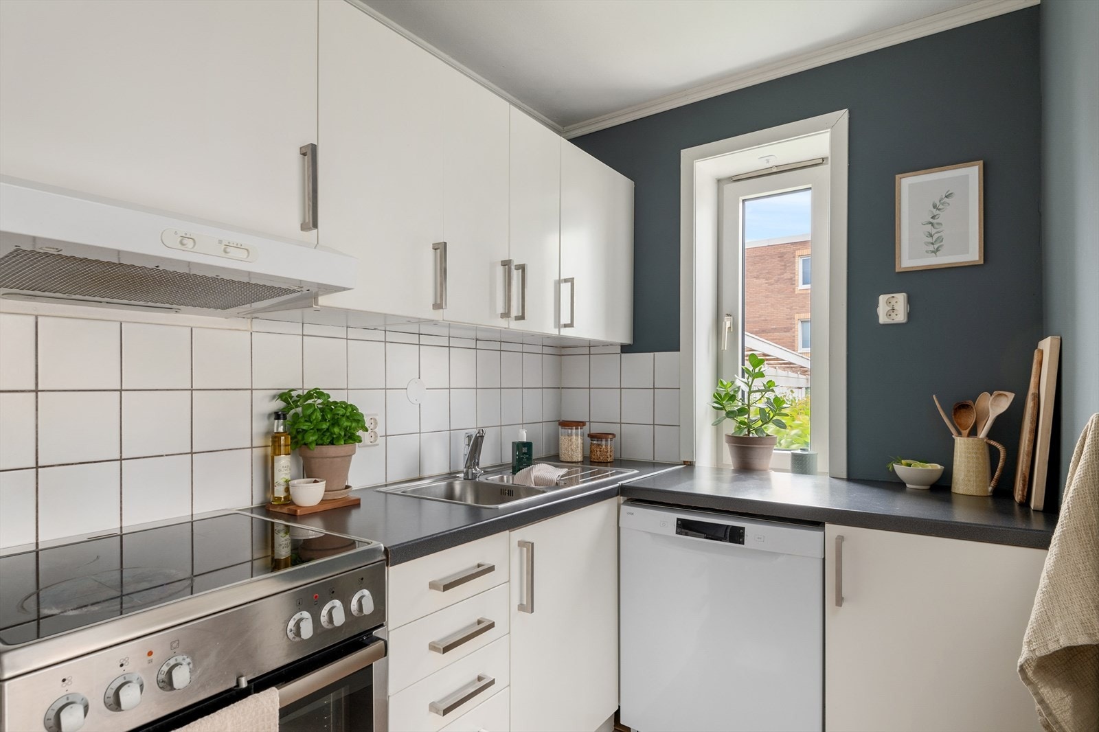 Hjørnet for kokkelering er innredet med mekanisk avtrekksvifte over stekesone og opplegg for oppvaskmaskin. Vinduet over kjøkkenbenk gir deg godt med arbeidslys og pen utsikt mot borettslagets fellesområder. Galleribilde