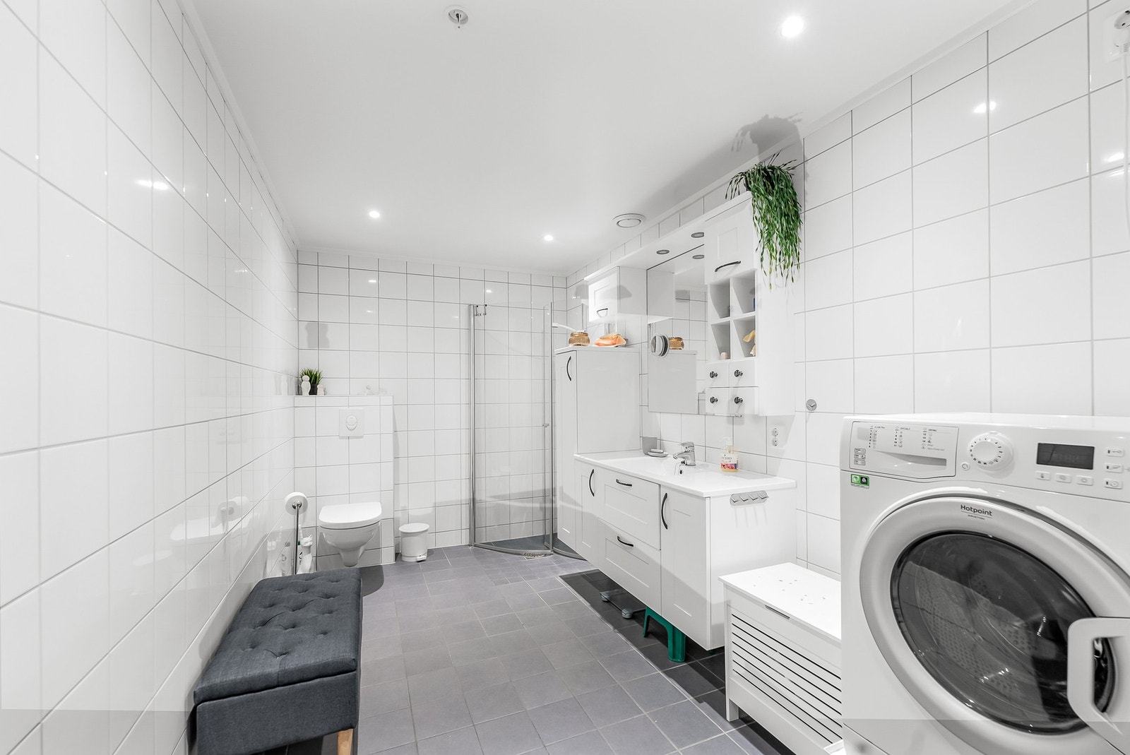 Badet har behagelig gulvvarme. Den praktiske baderomsinnredningen skaper godt med oppbevaringsplass. Galleribilde
