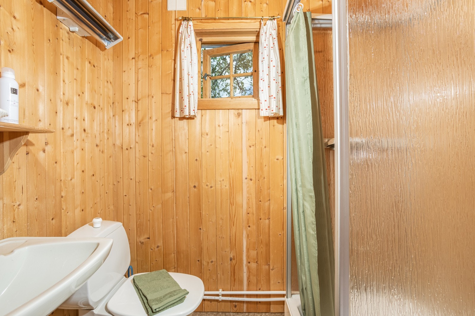 Badet er innredet med servant, dusjhørnet og toalett. Galleribilde