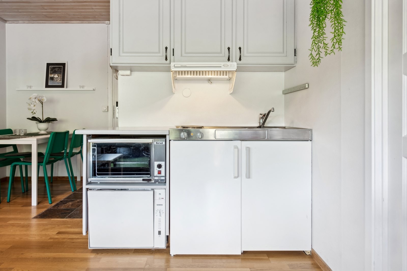 Praktisk kjøkken med alt hva du trenger- oppvaskmaskin, stekeplater, ovn, kjøleskap, og profilerte overskap til lagring. Galleribilde