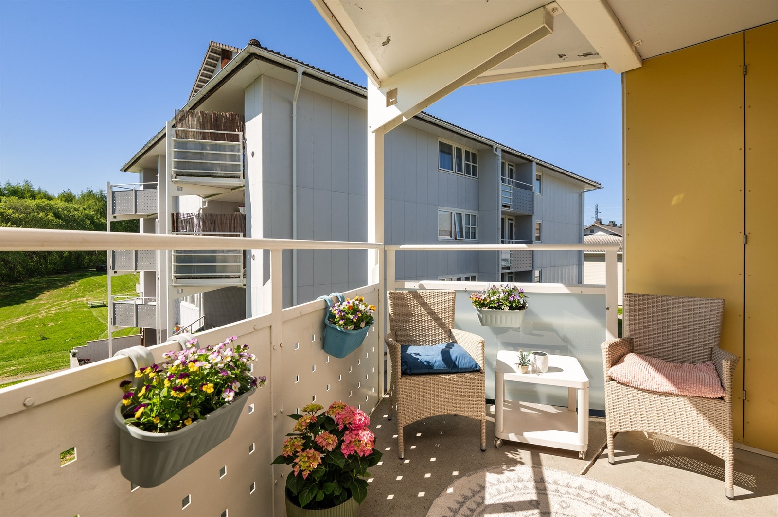 Balkongen ligger avskjermet til på enden av bygget med utsikt mot turterreng. Selger opplyser om solgang fra ca. kl. 09:30 til 19:30 på sommerstid. Galleribilde