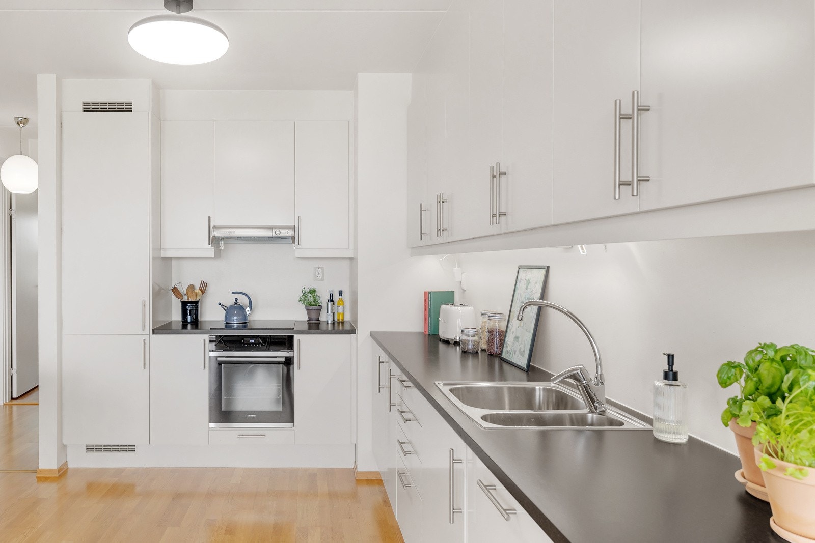 Innredningen har slette fronter i hvit utførelse samt laminert benkeplate. Galleribilde