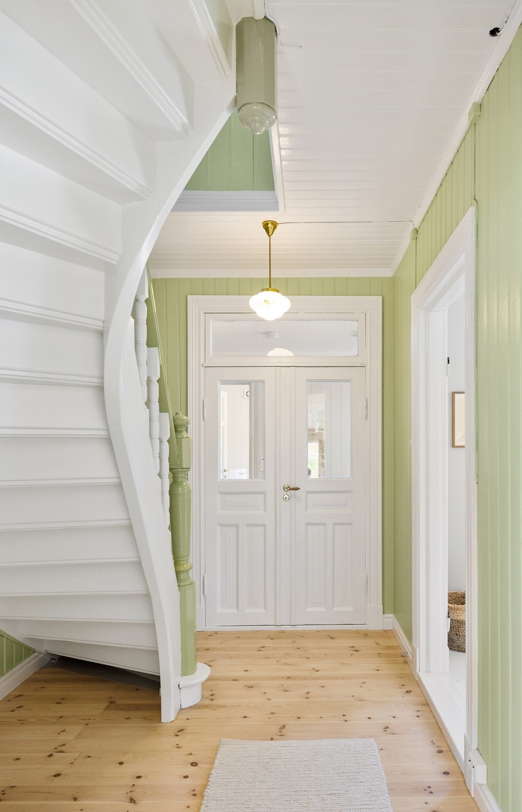 Trappen som binder første og andre etasje sammen svinger seg elegant i rommet. Det er doble dører mellom gangen og hallen i tilbygget. Galleribilde