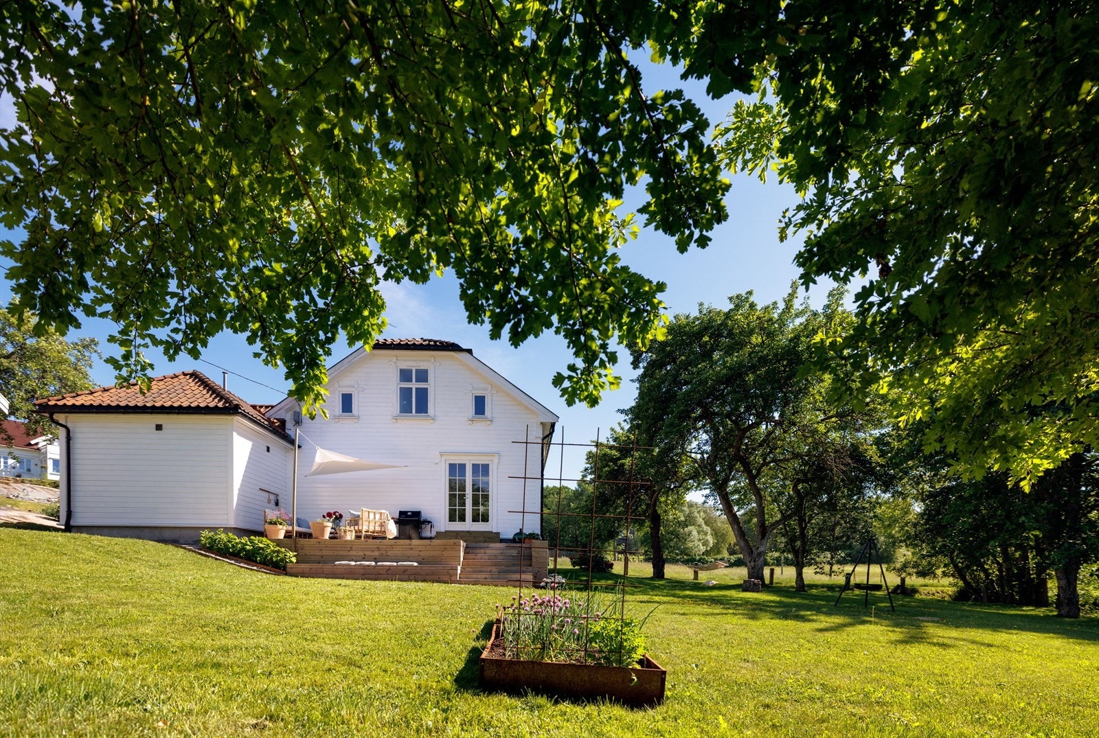 Her vokser store gamle løvtrær og ikke minst hagens gamle frukttrær som blomstrer nydelig på våren, og senere på året gir husholdningen en rikelig innhøsting. Galleribilde