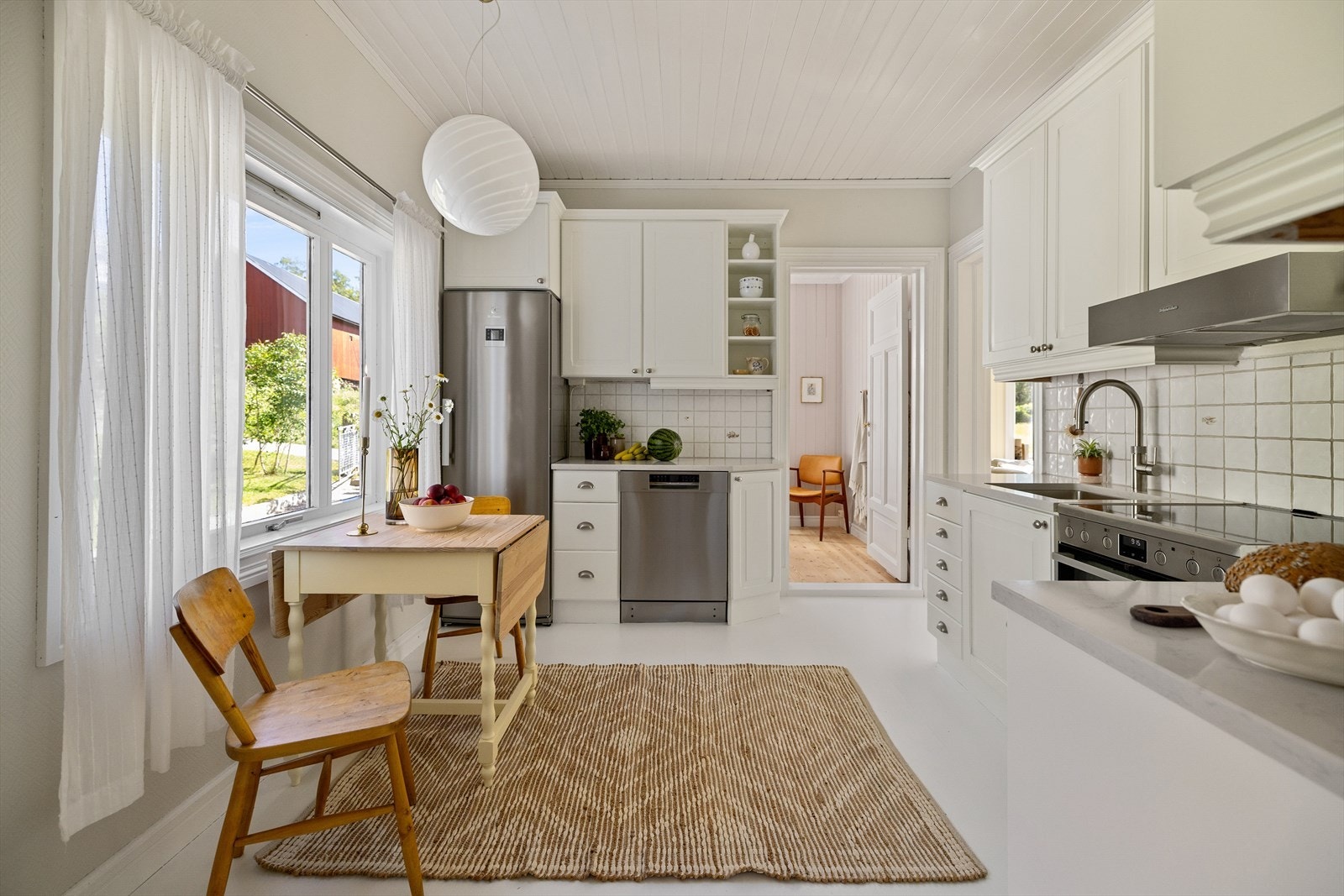 Kjøkkenet er klassisk med hvite, profilerte fronter mot gråmalte vegger. Galleribilde