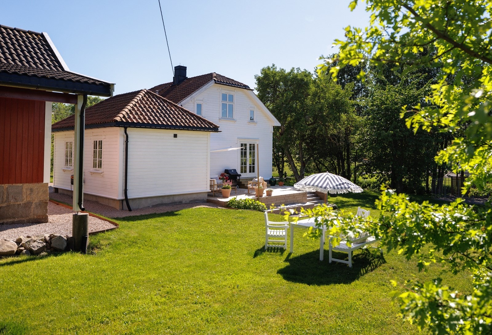 Hovedboligen strekker seg over to etasjer i klassisk stil og halvvalmet tak - et hjem som fremstår både flott og velholdt. Galleribilde