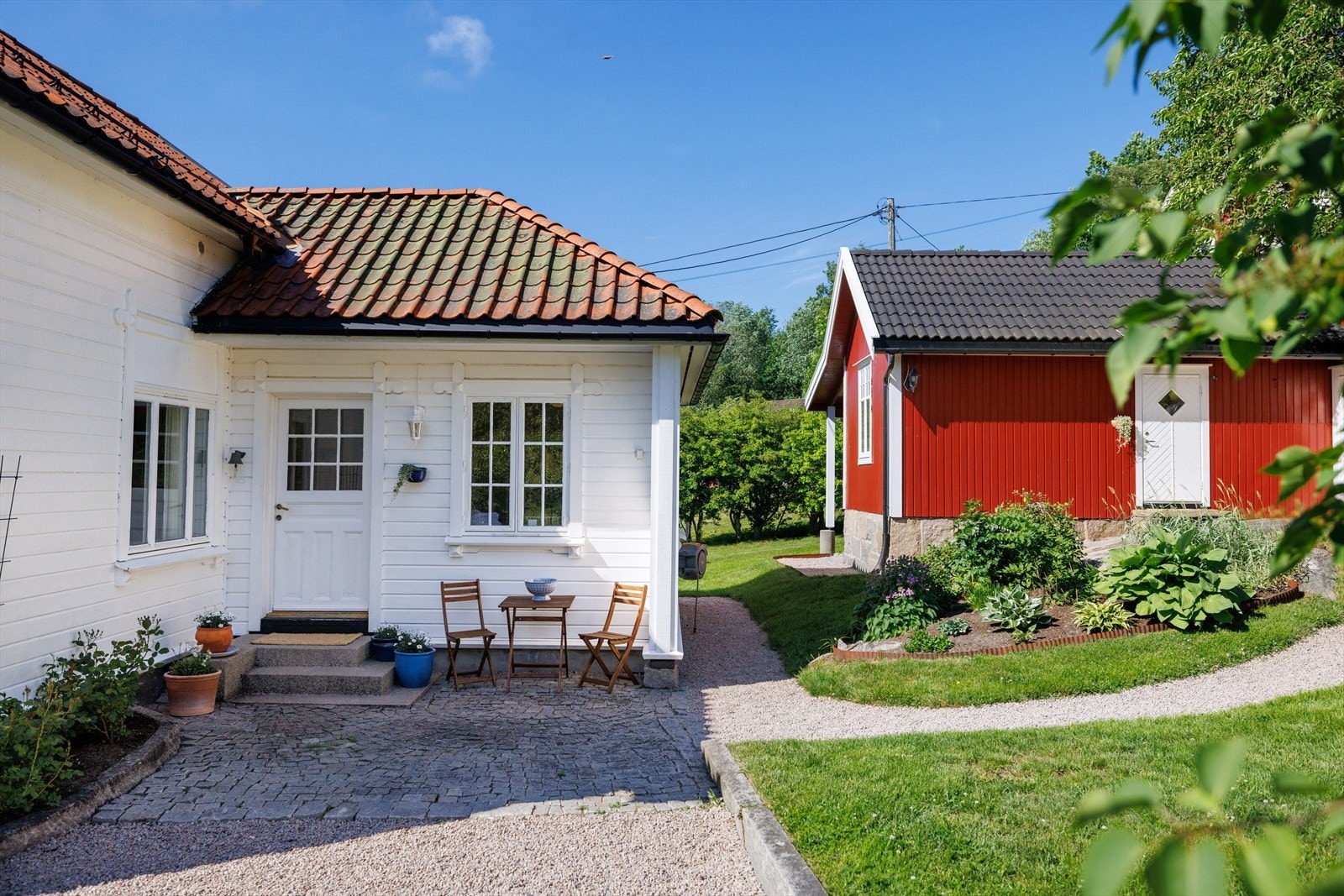 Opp mot inngangsdøra løper en sti belagt med ekte brostein. Ved trappen brer den seg ut i en fin sitteplass Galleribilde