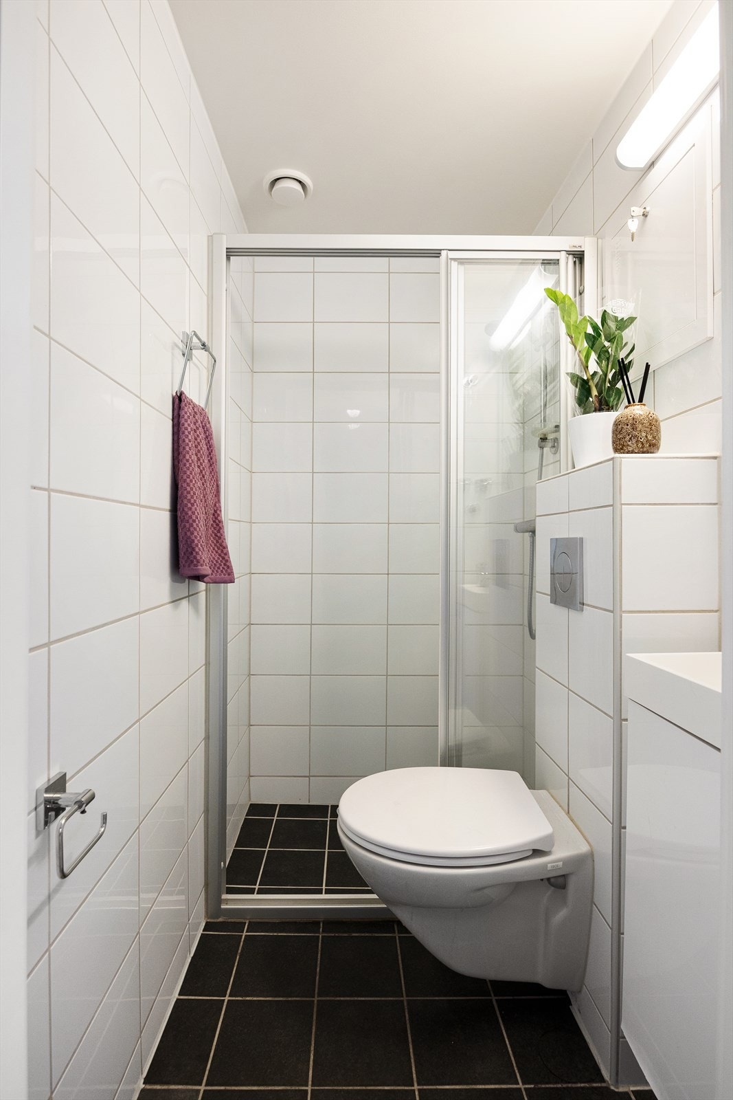 Delikat flislagt baderom fra 2014 med varmekabler i gulv. Badet består av wc, dusjplass med vegger og servant med ettgreps blandebatteri. Galleribilde