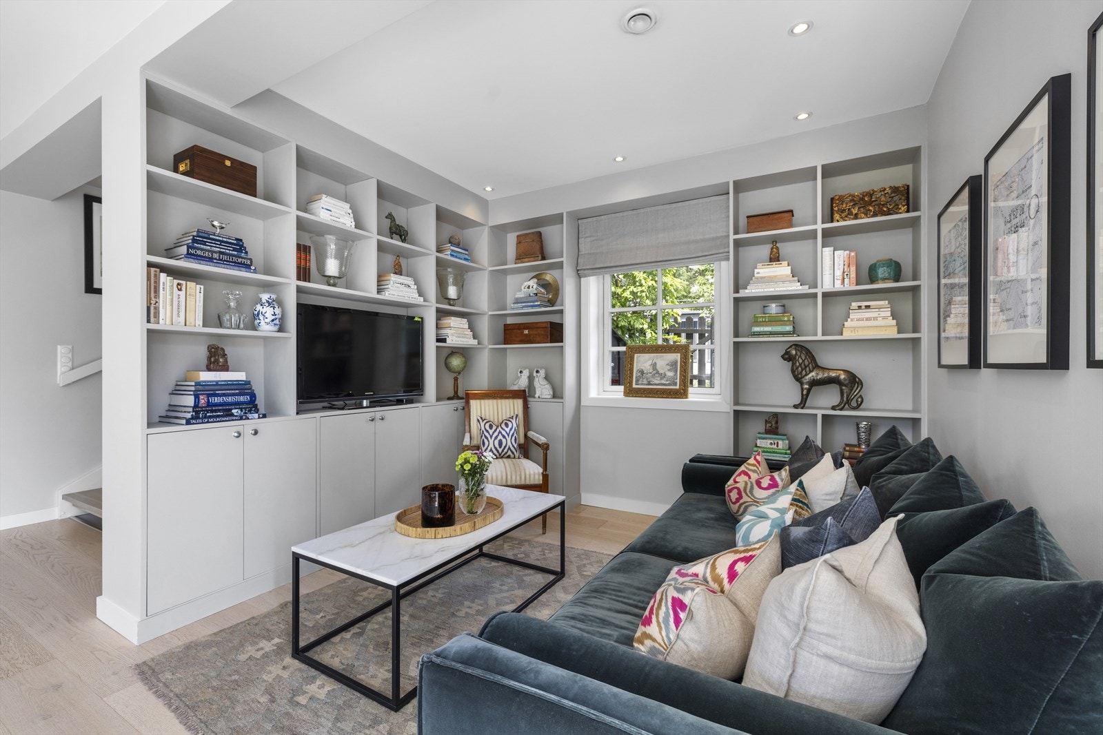 Hyggelig tv-krok med plassbygget seksjon og bokhyller Galleribilde