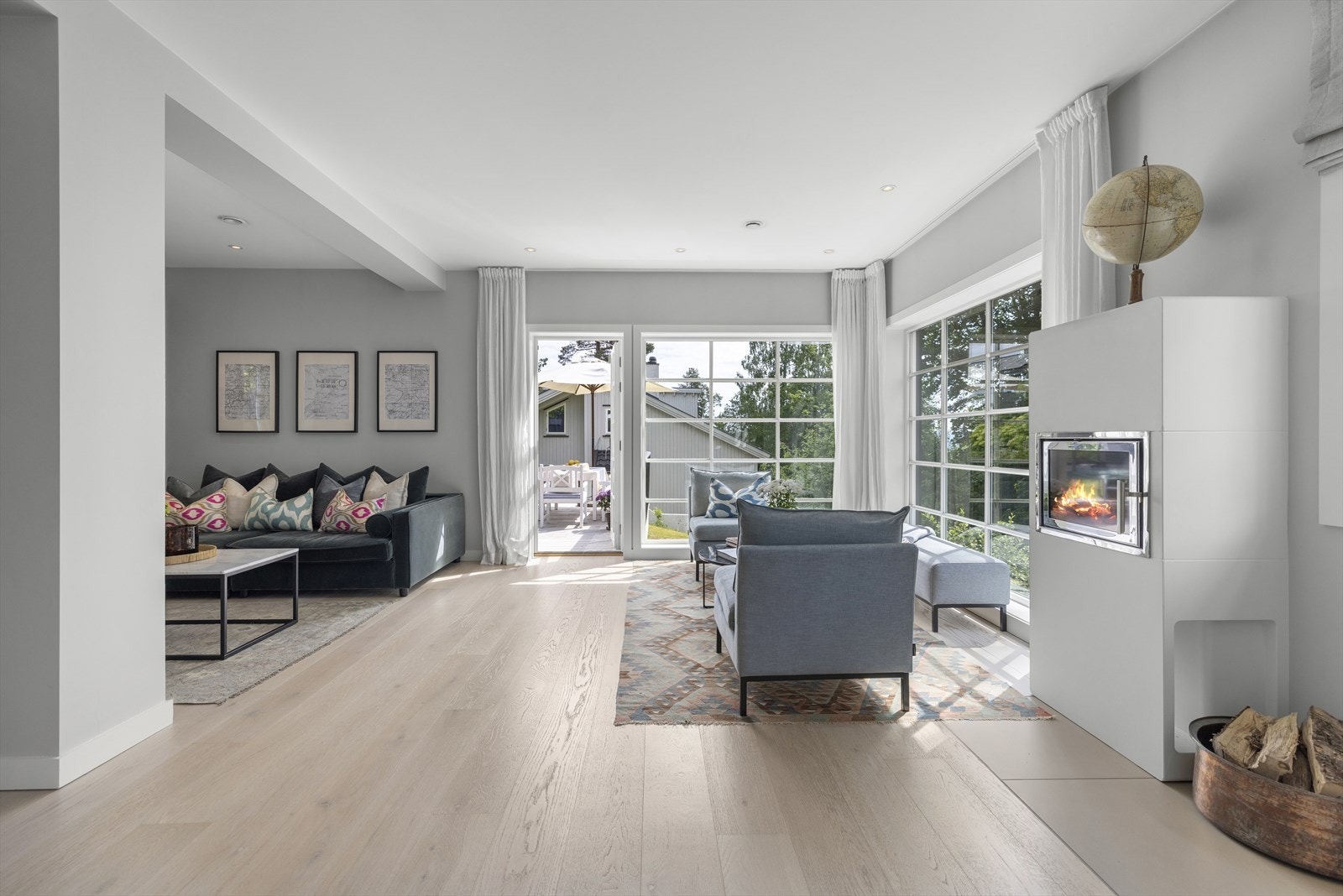 En hyggelig og dekorativ peis deler stuen fra spisetuen Galleribilde