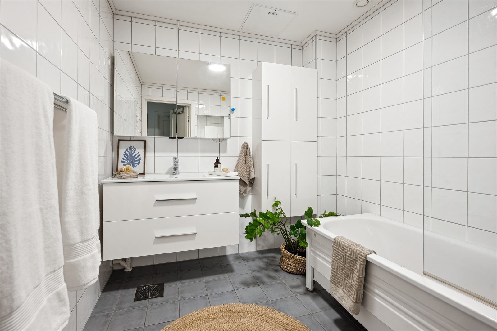 Stort flistlagt bad med varmekabler i gulv og downlights i himlingen. Galleribilde
