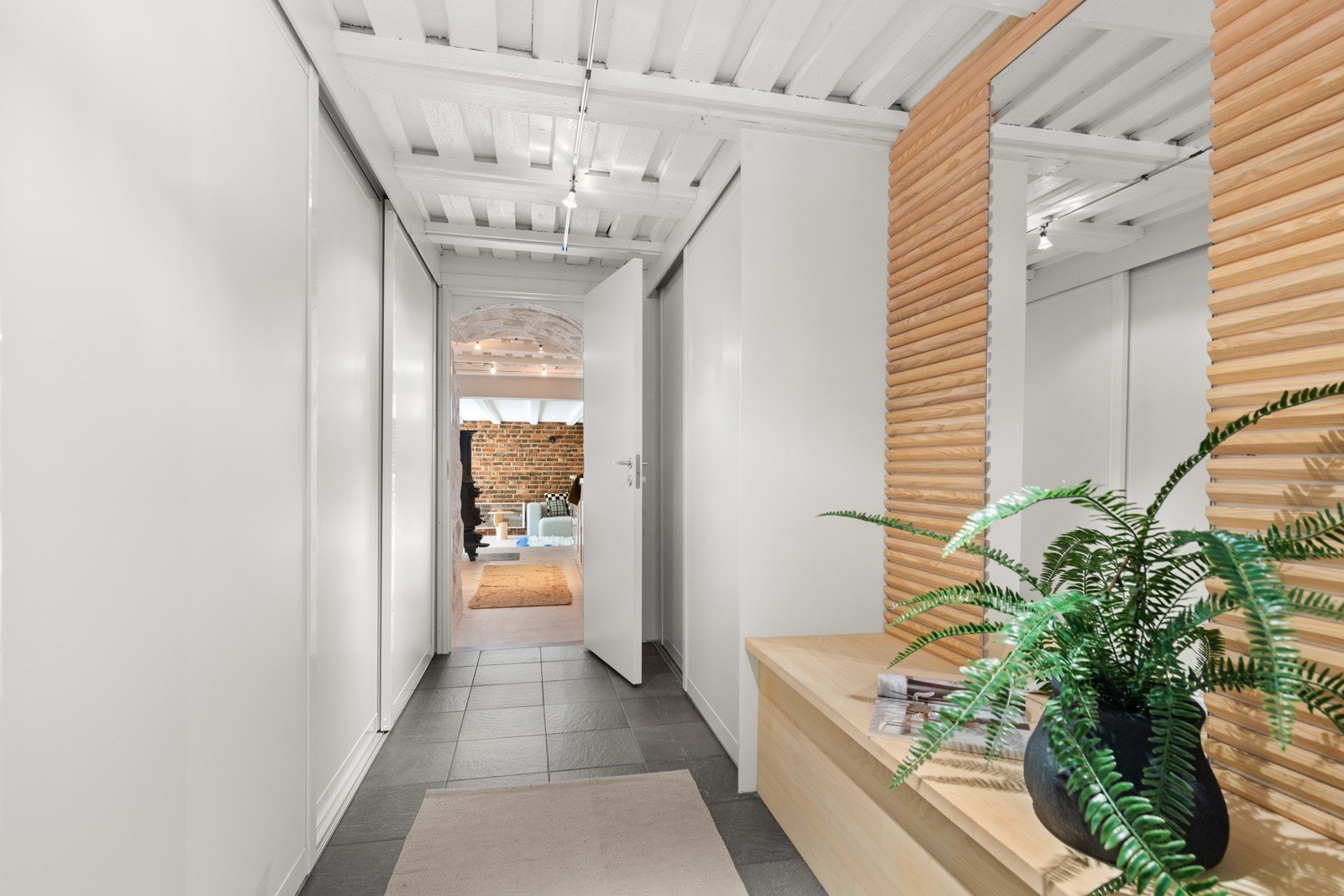 Det er godt med oppbevaringsplass i stort garderobeskap. Benk med speil er tegnet av arkitekt og plassbygget av snekker. Galleribilde