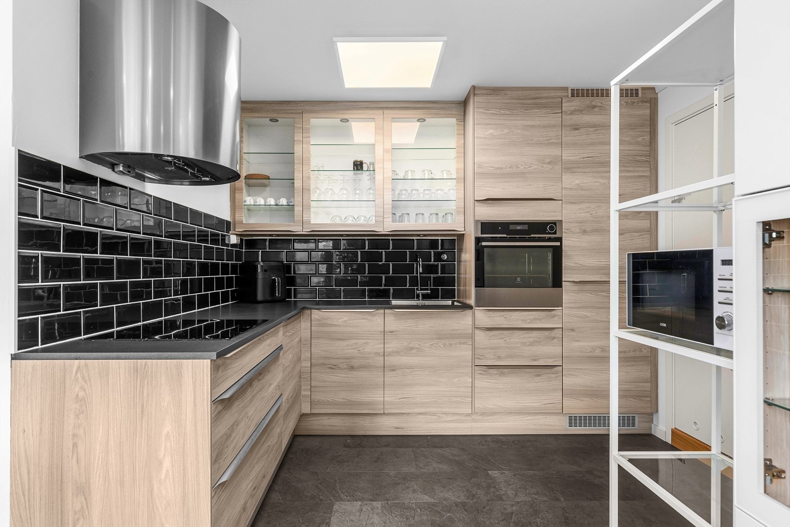 Integrert oppvaskmaskin (AEG), induksjonstopp (AEG), stekeovn (Electrolux) og kombinert kjøle-/fryseskap (Electrolux). Galleribilde