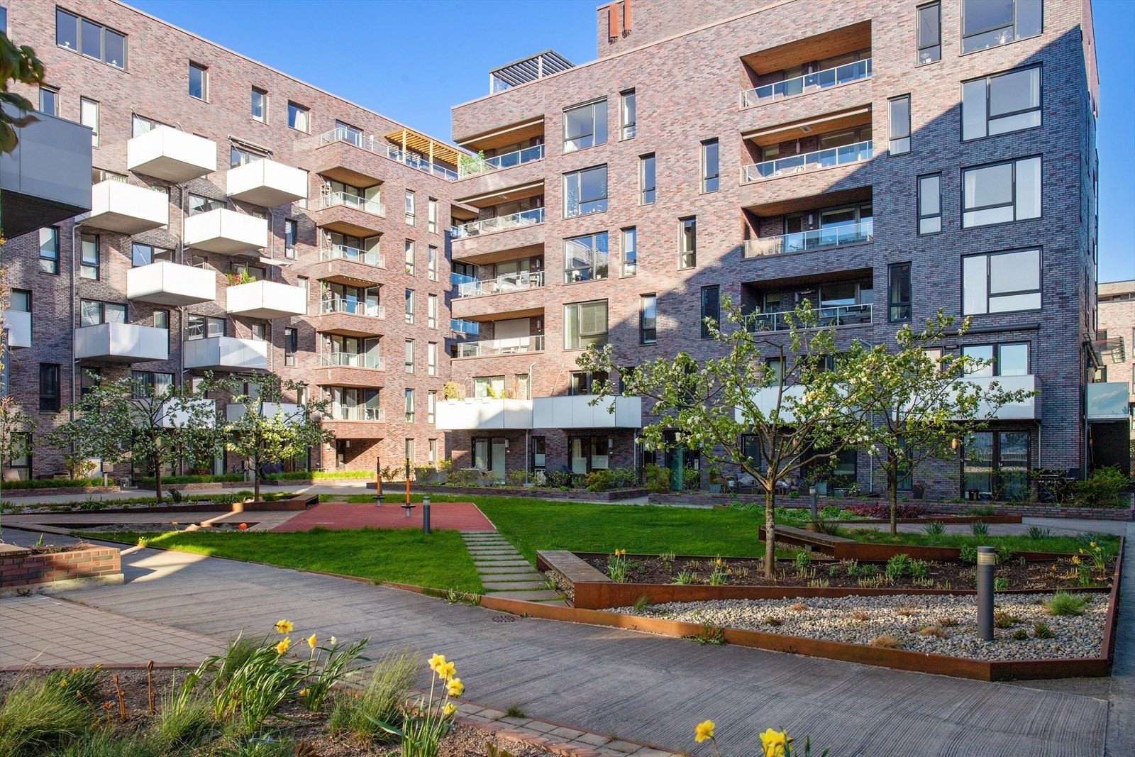 Pent opparbeidet bakgård med beplantning, lekeplass m.m. Galleribilde