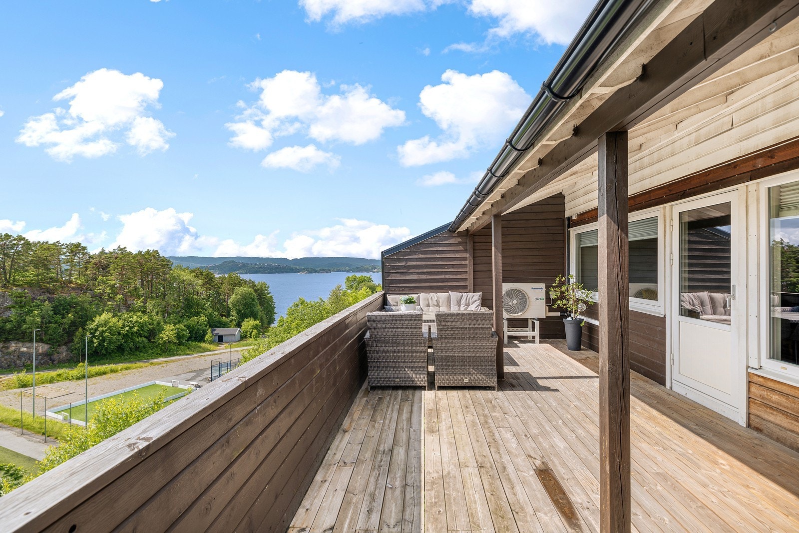 Romslig veranda som møbleres med sittegruppe, grill og div. beplantning Galleribilde