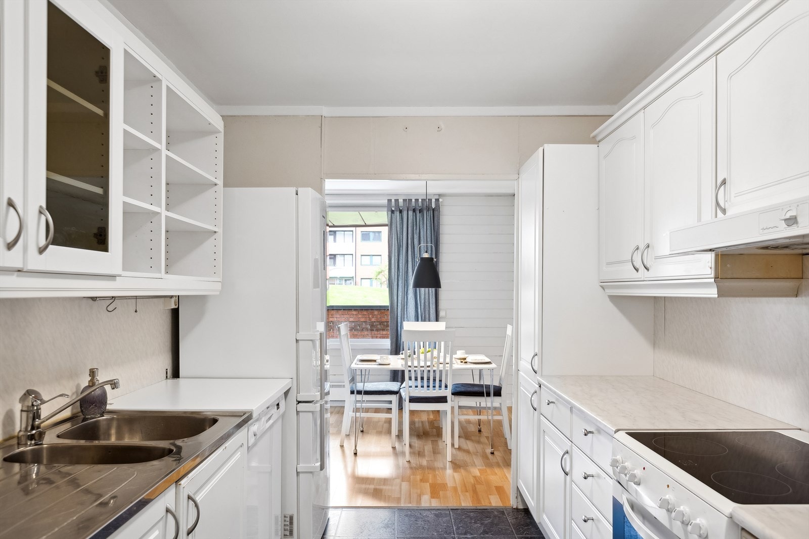 Kjøkken med folierte skrog med profilerte fronter og laminert benkeplate. Plater på vegg over benkeplate Galleribilde